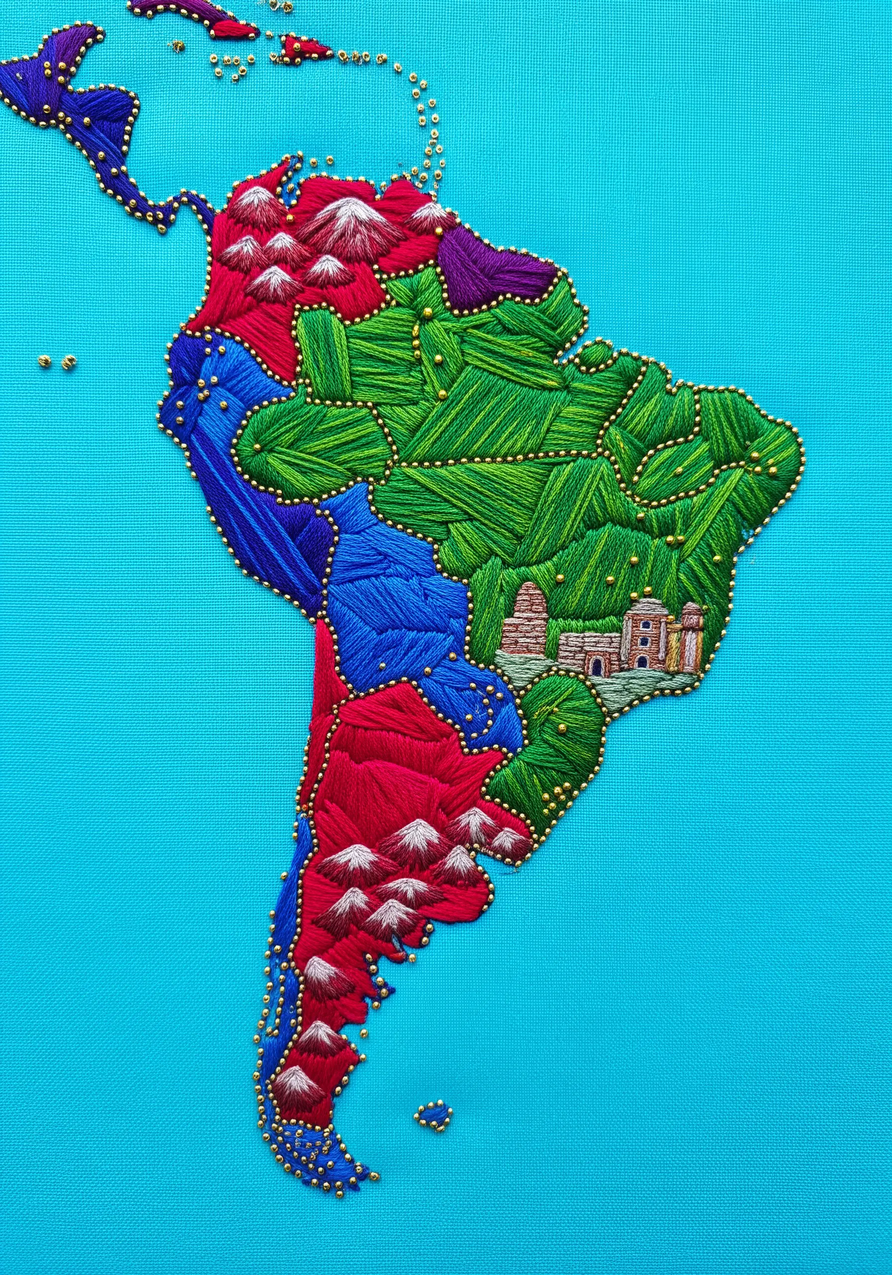 Embroidered map of South America with colorful satin stitch and gold bead outlines.