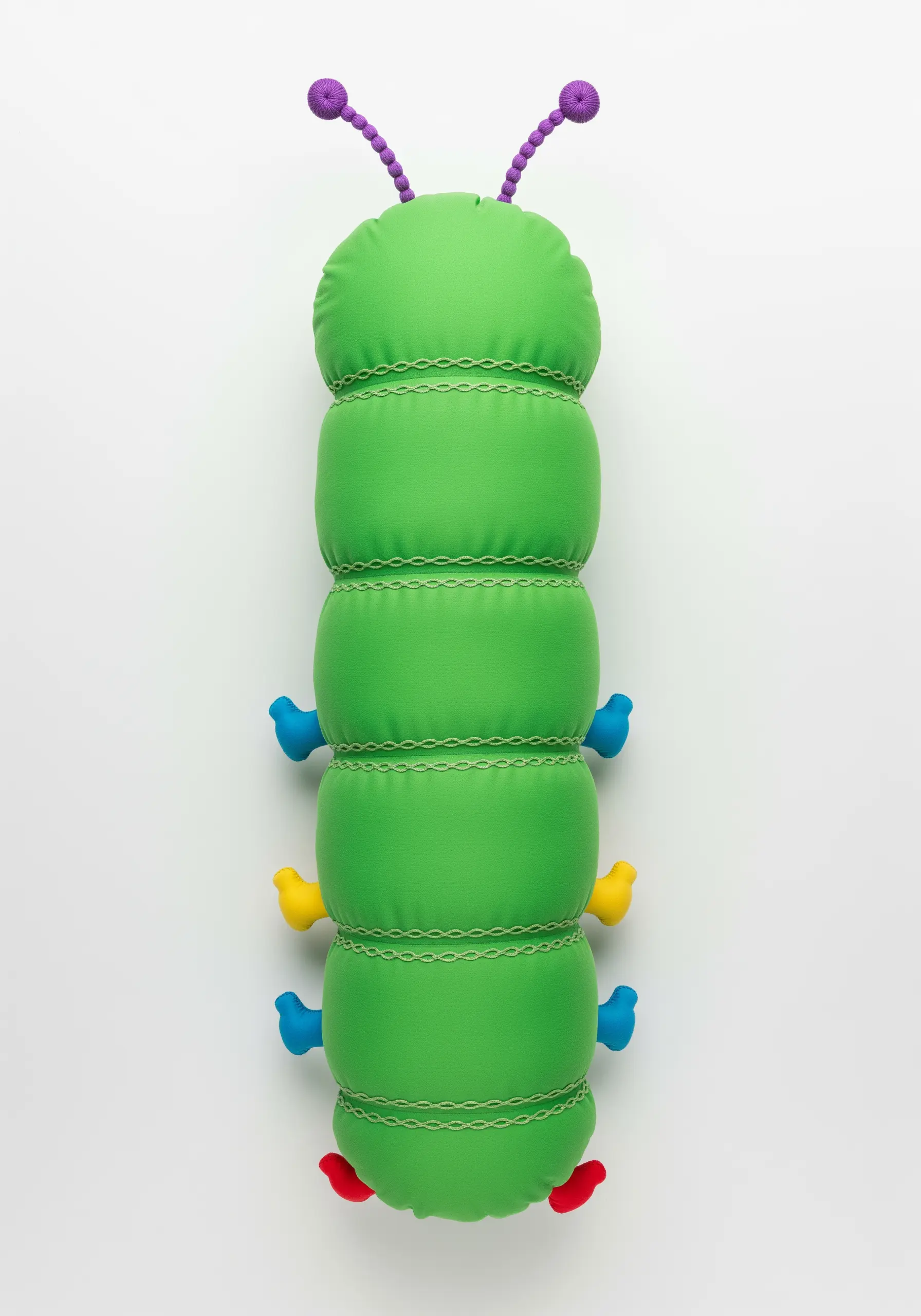 A green segmented caterpillar pillow with decorative chain stitch embroidery.