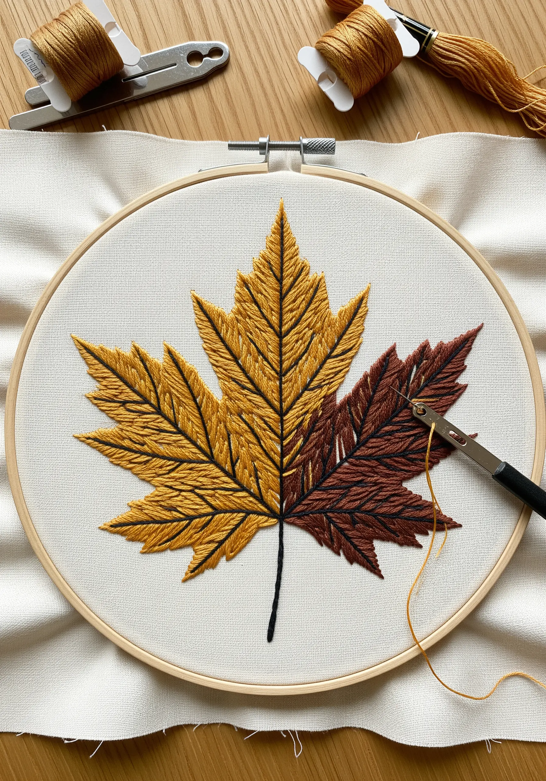 Embroidered autumn maple leaf with sharp, graphic color blocking in gold and brown.