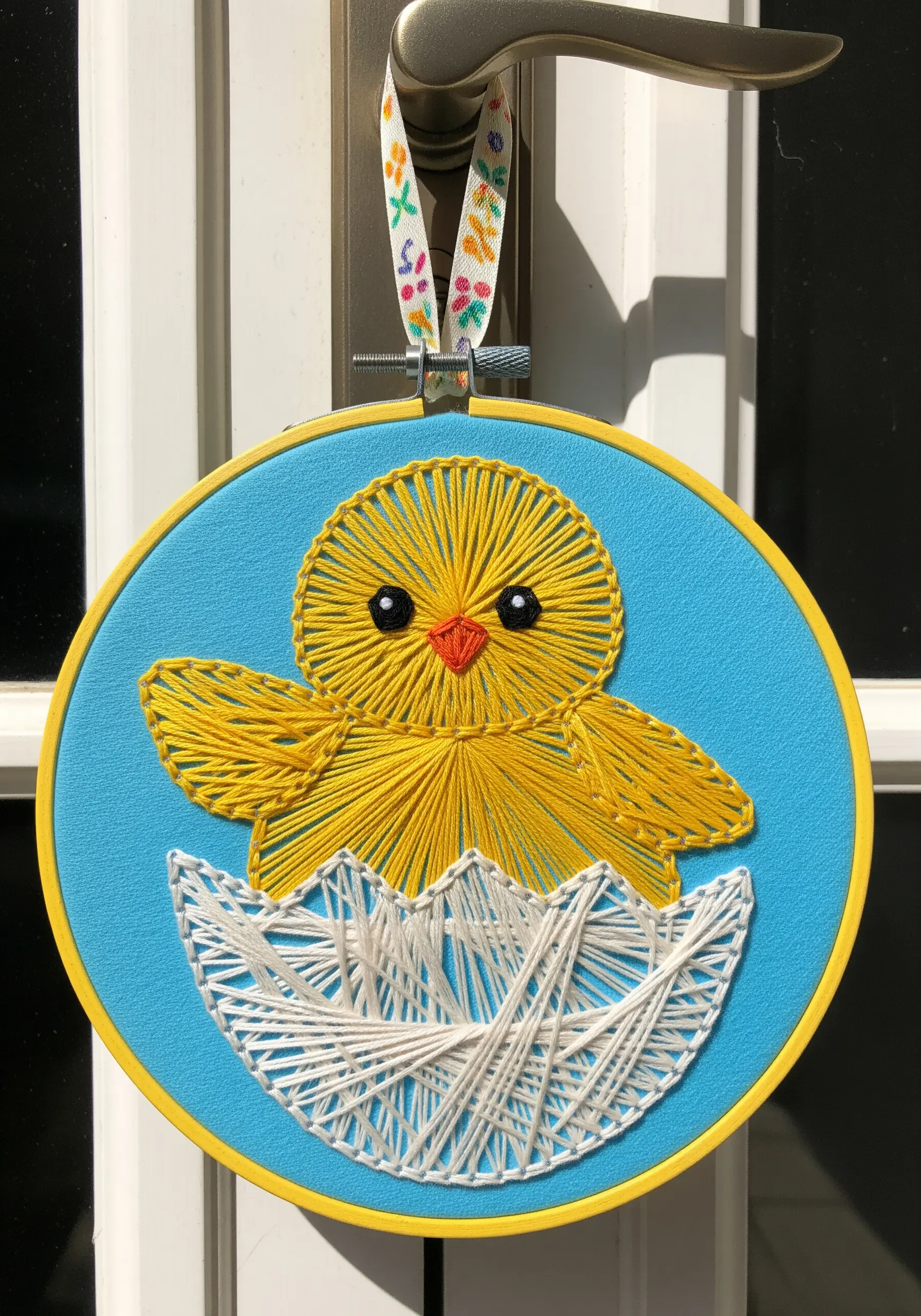 String art chick and eggshell using radiating and angular stitches.