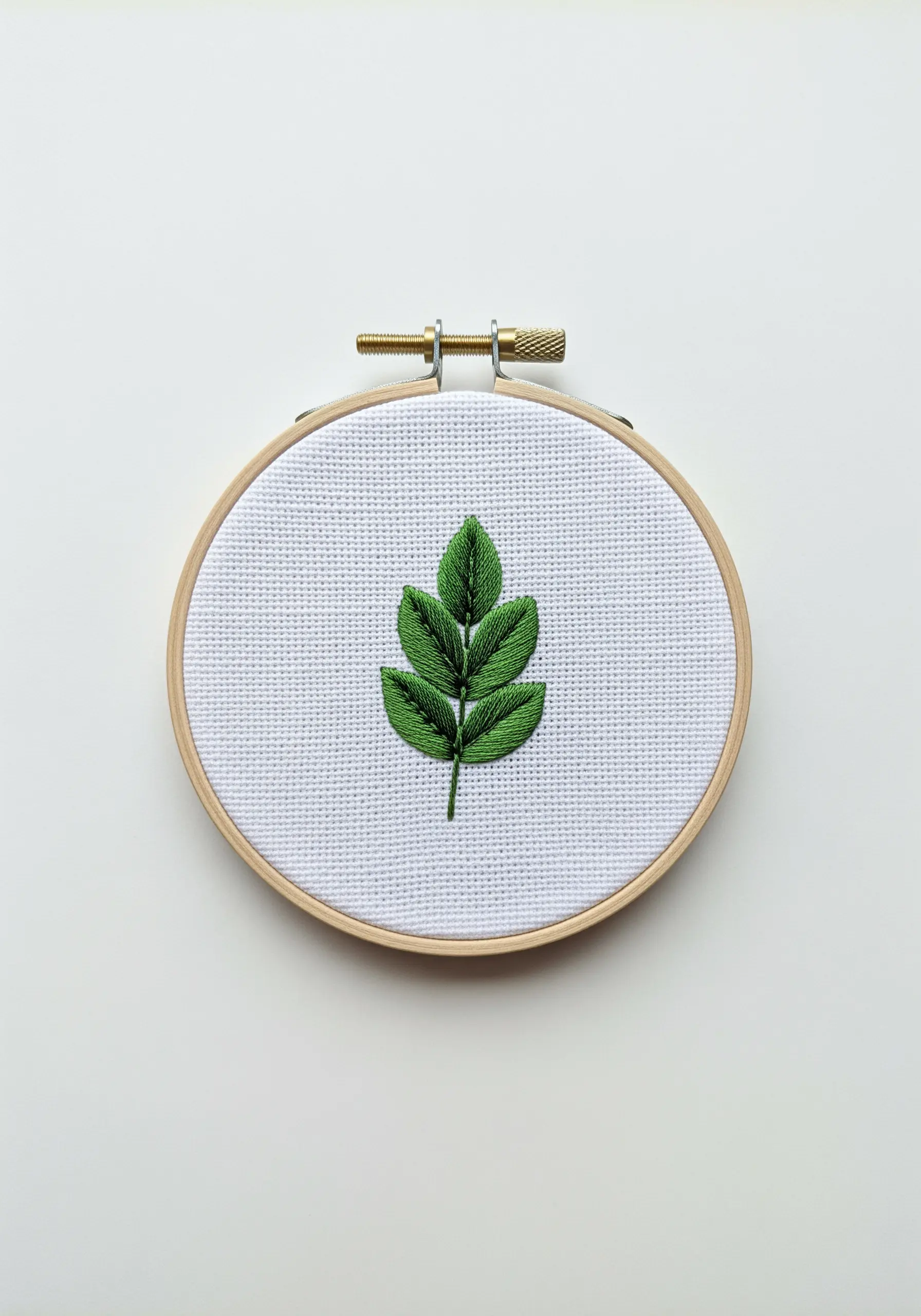 A small green leaf with a split stitch vein and outline, creating neat sections for satin stitch.