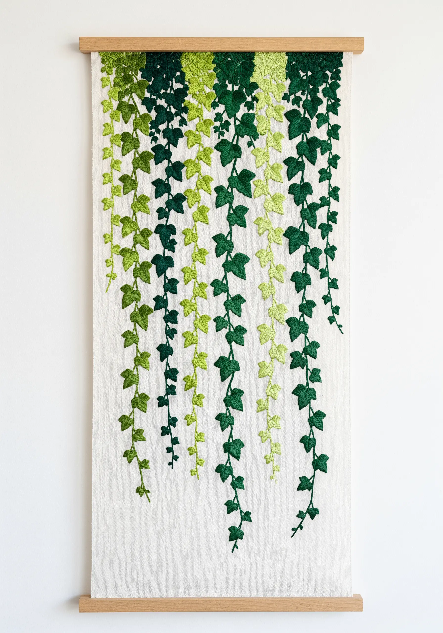 A long wall hanging with cascading ivy leaves embroidered in a green gradient.