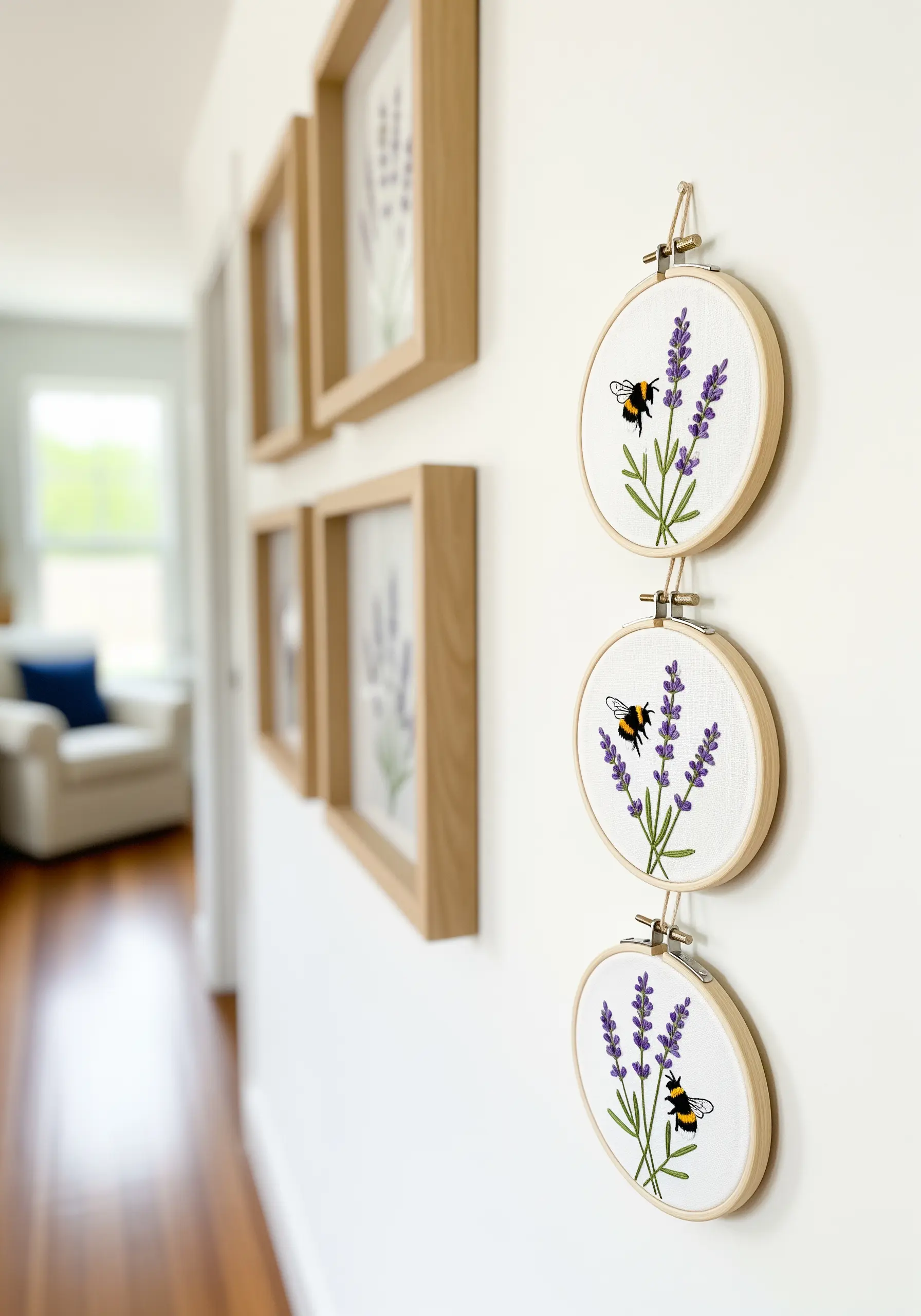 A vertical series of three small embroidery hoops with lavender and bees.