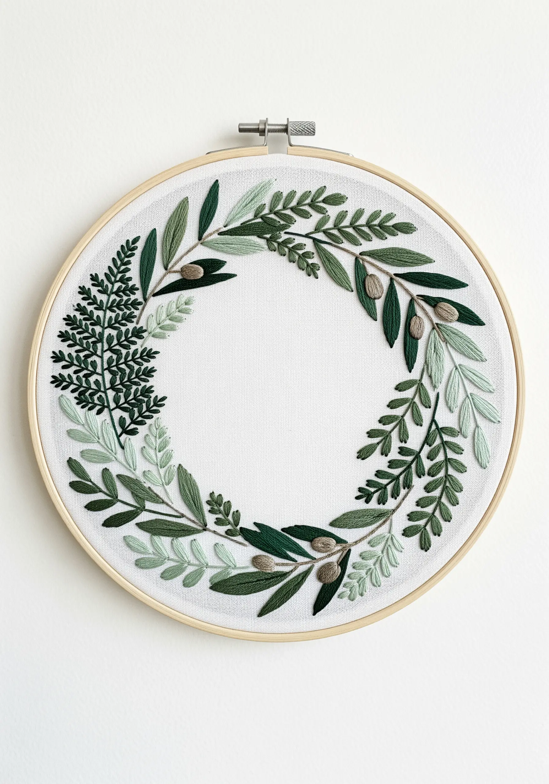 A monochromatic embroidery wreath featuring various leaf shapes in different shades of green.