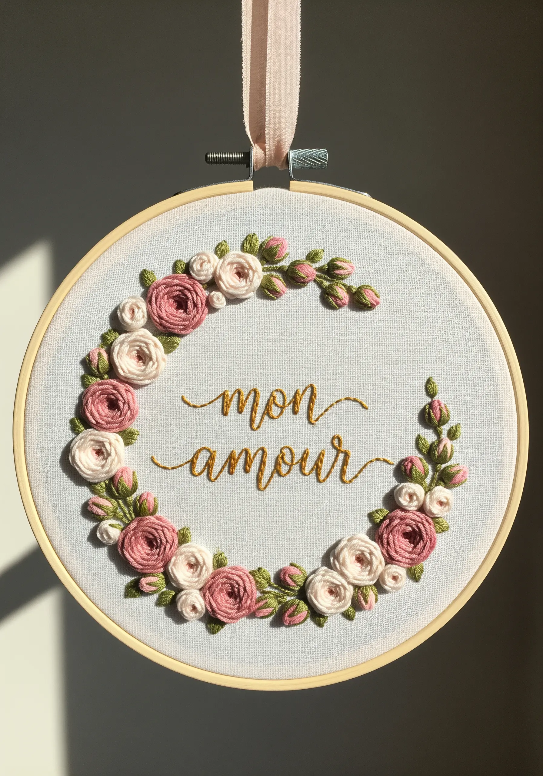 A floral wreath of pink and cream woven wheel roses and buds embroidered in a hoop.
