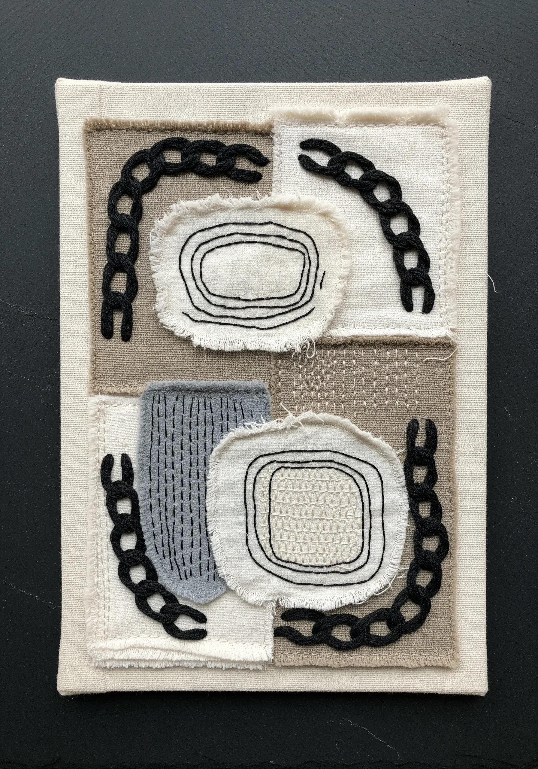 Neutral-toned fabric collage with raw edges and bold, black chain stitch outlines.