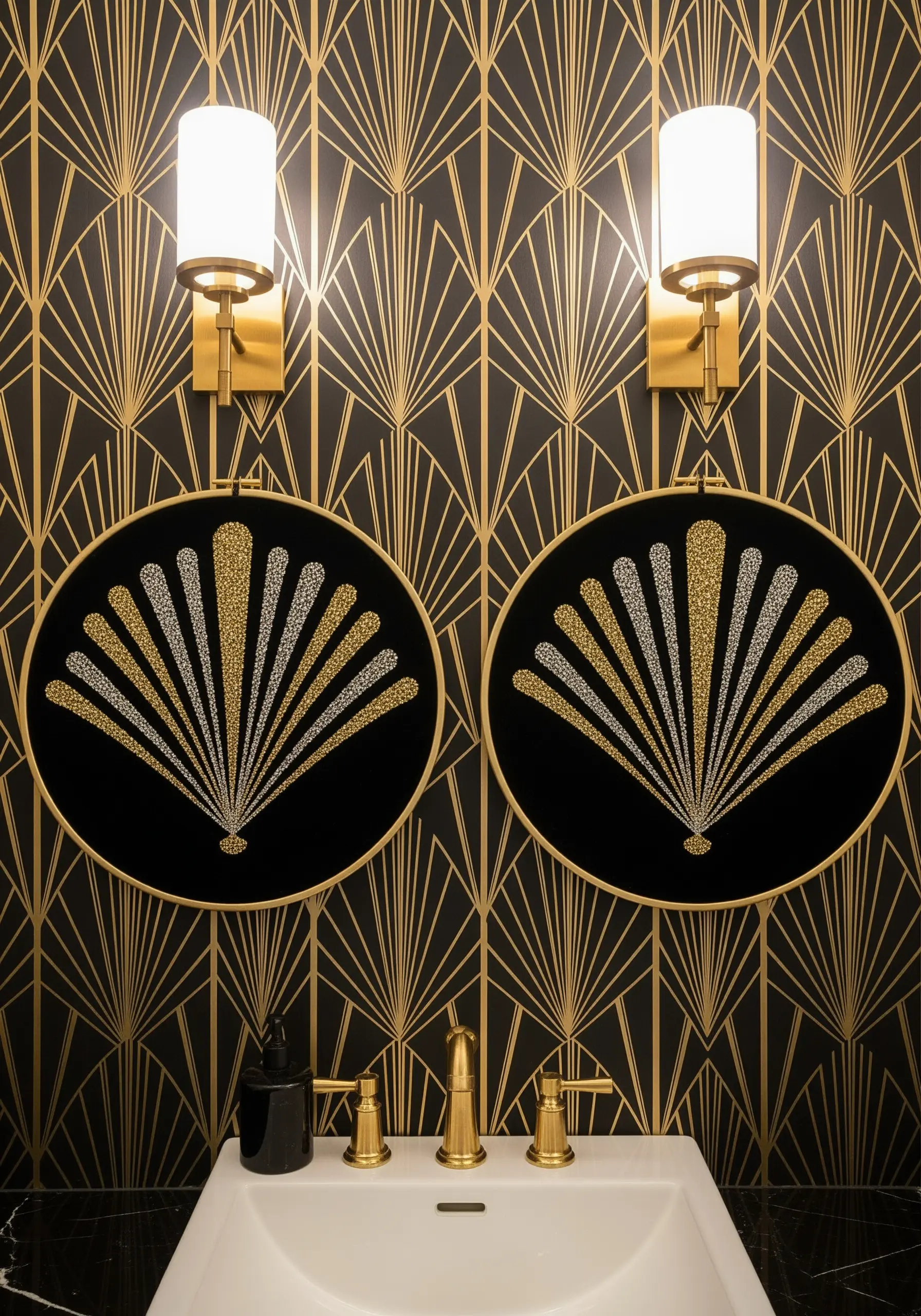 Two black embroidery hoops with gold and silver metallic thread in an Art Deco fan pattern.