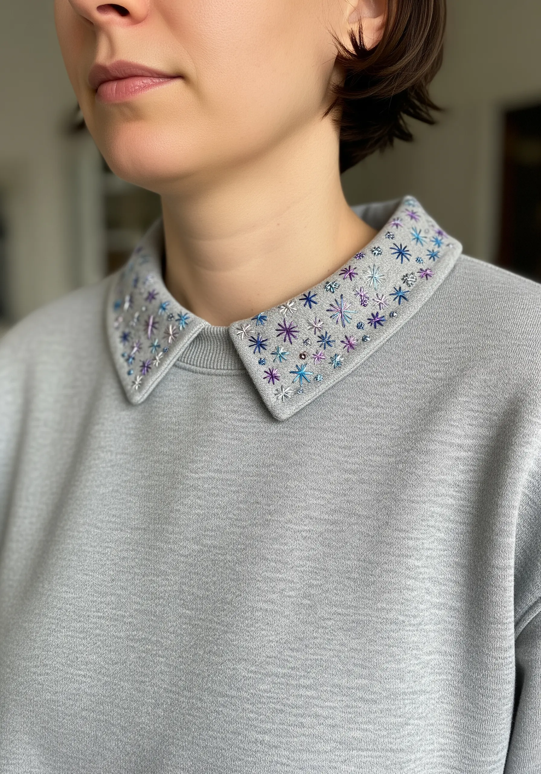 A sweatshirt collar embellished with scattered star stitches and colorful beads.