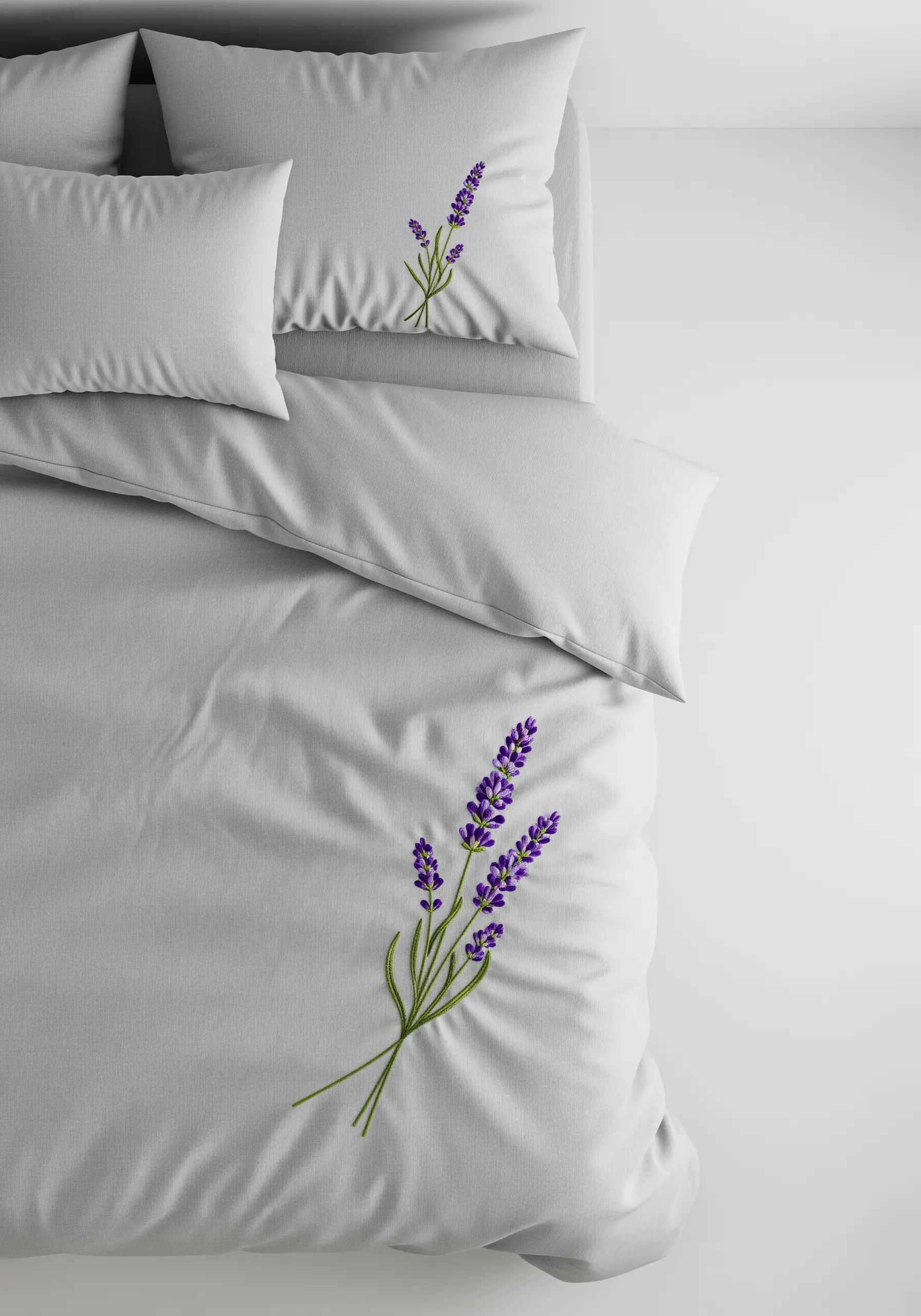 A single sprig of lavender embroidered on a pale grey duvet and pillowcase.