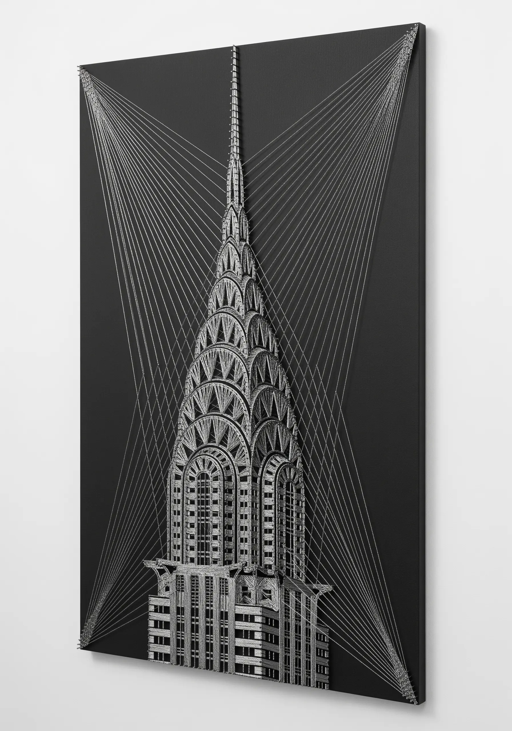Detailed string art of the Chrysler Building in white thread on a black canvas, highlighting its Art Deco spire.