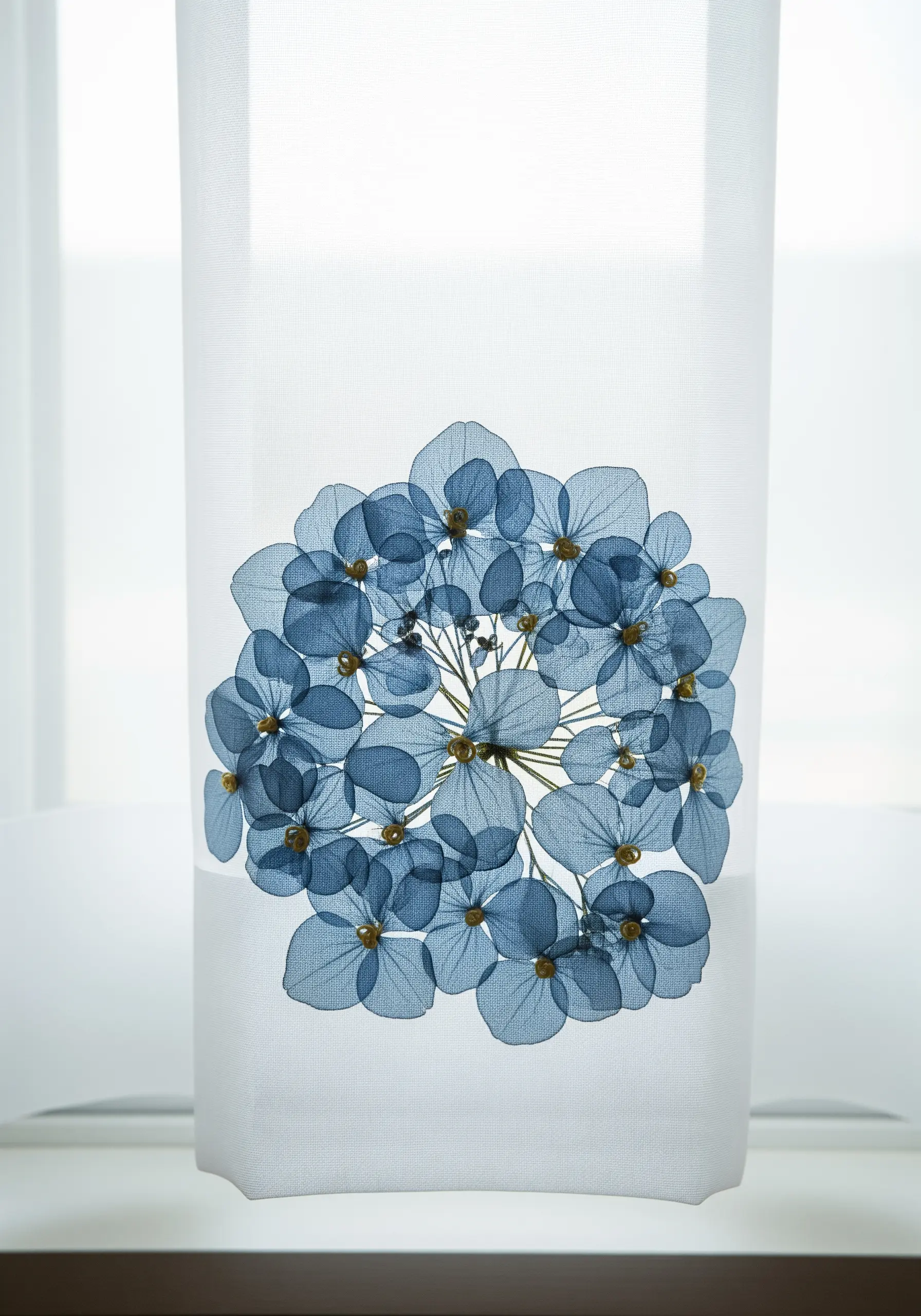 A sheer white curtain featuring a large, intricate bloom made from pressed blue hydrangea petals.