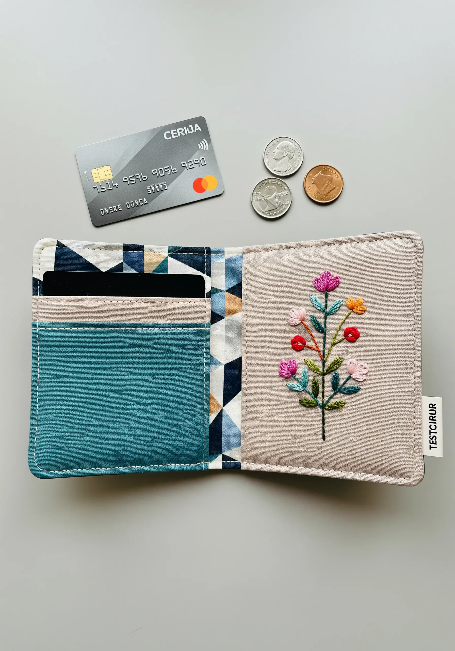 An open wallet with a small, colorful embroidered floral bouquet on the fabric exterior
