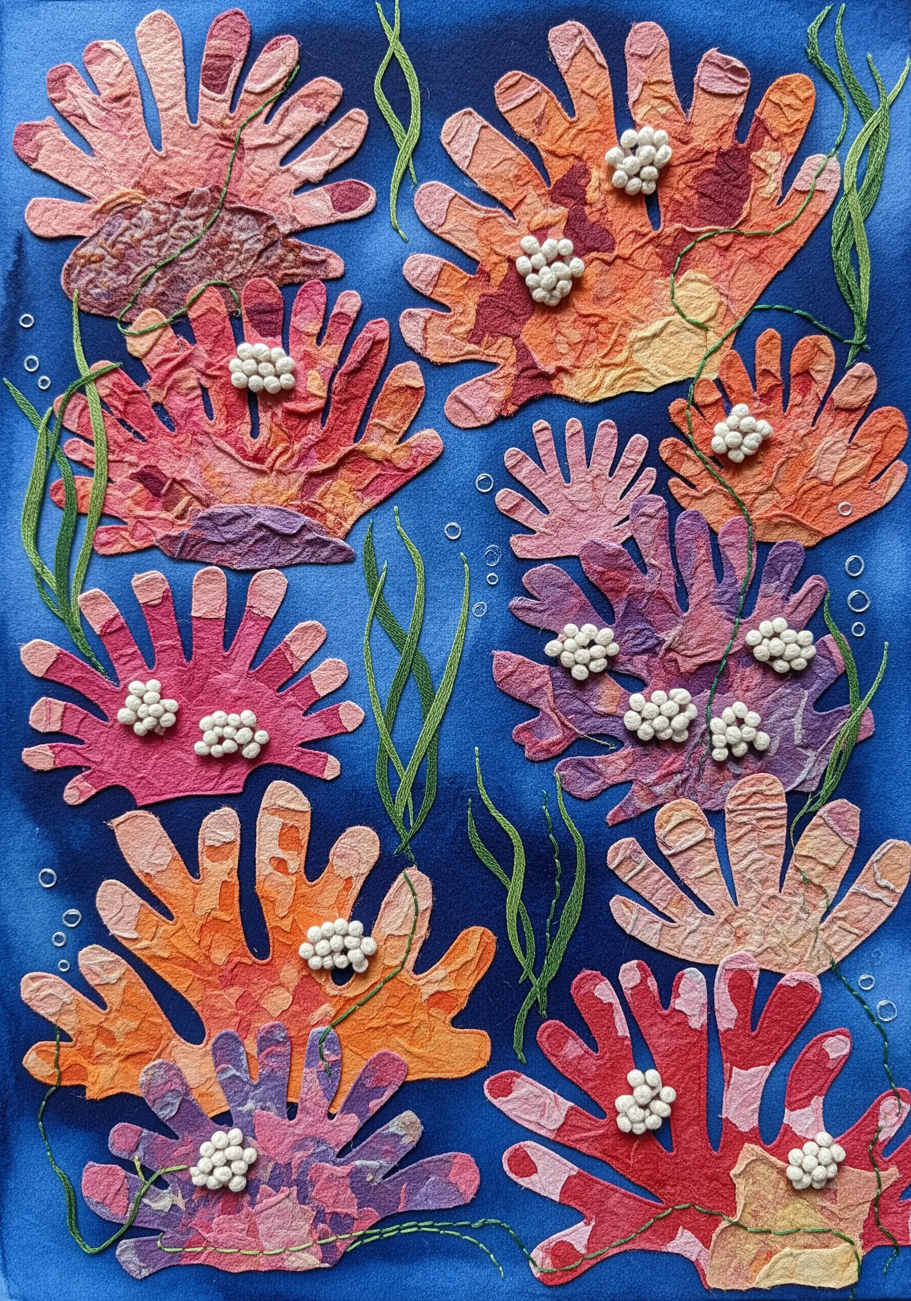 An underwater scene with paper coral decorated with dense clusters of white French knots and beads.