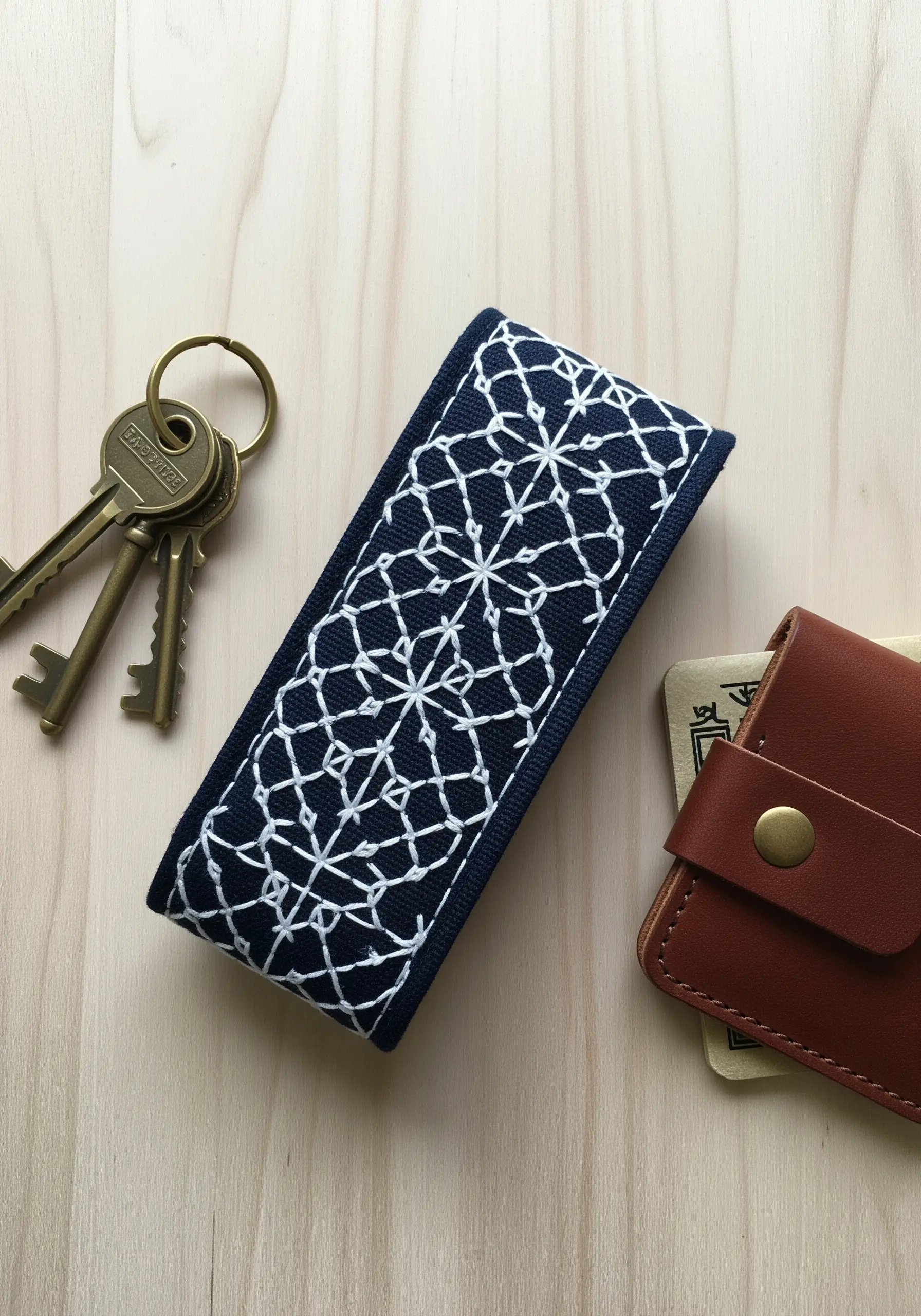 A traditional Japanese sashiko geometric pattern stitched in white on a navy blue key fob.