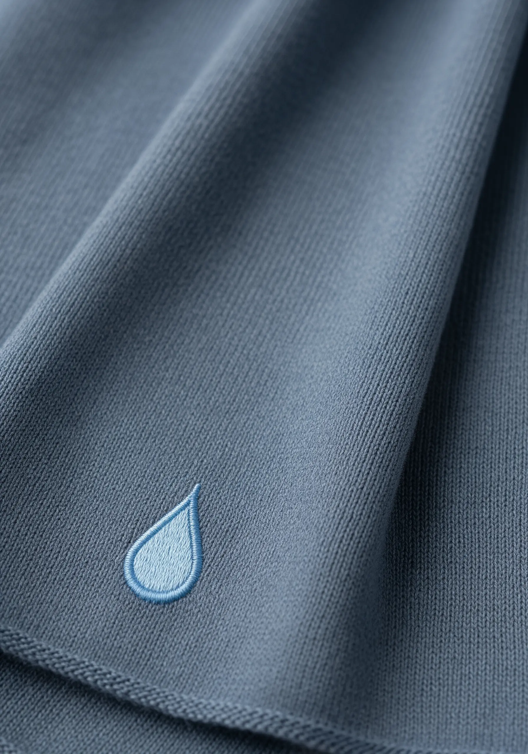 A single embroidered raindrop with a smooth blue gradient and dark blue outline.