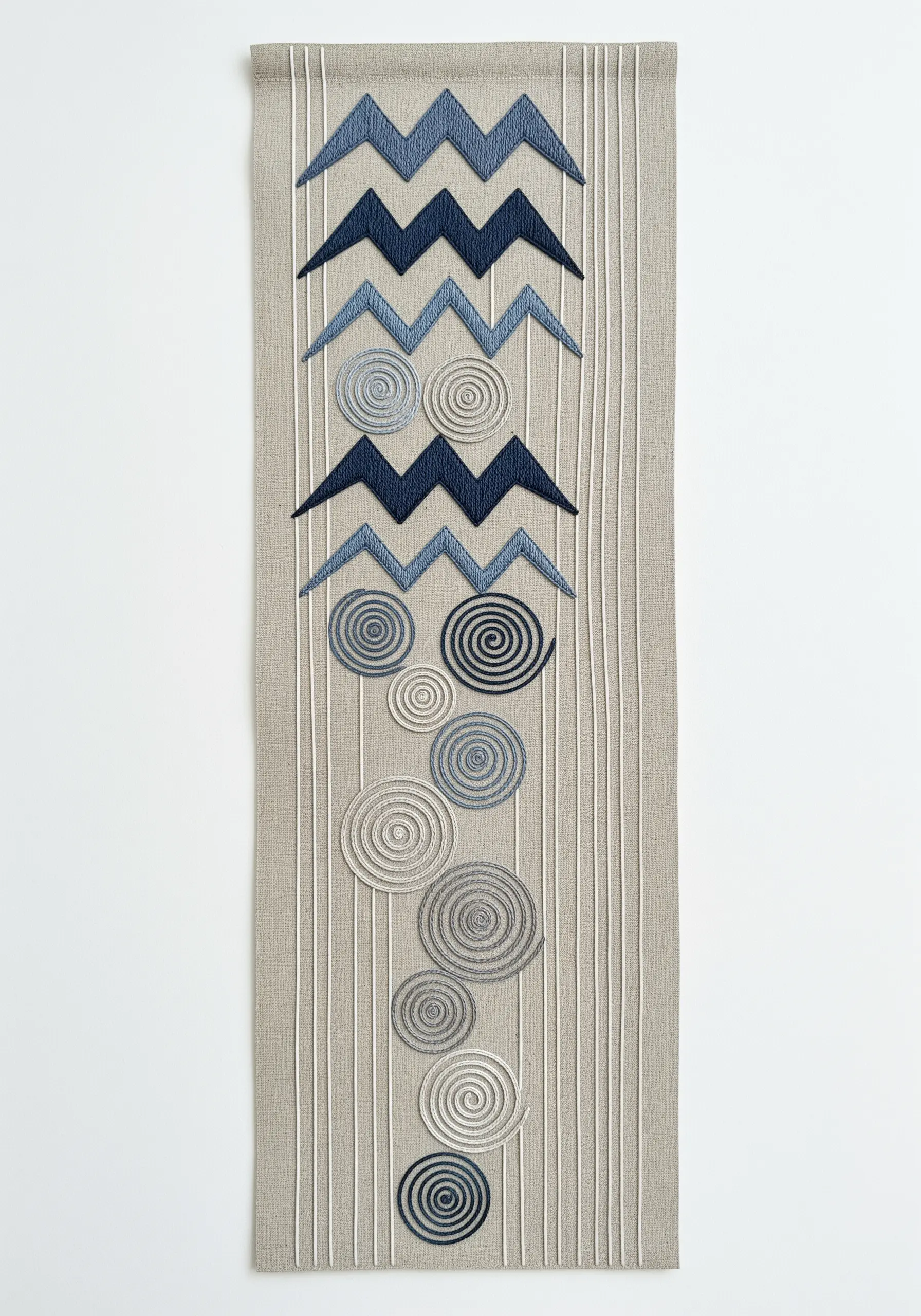 Long table runner with blue embroidered zigzags at the top and spirals fading down the length.