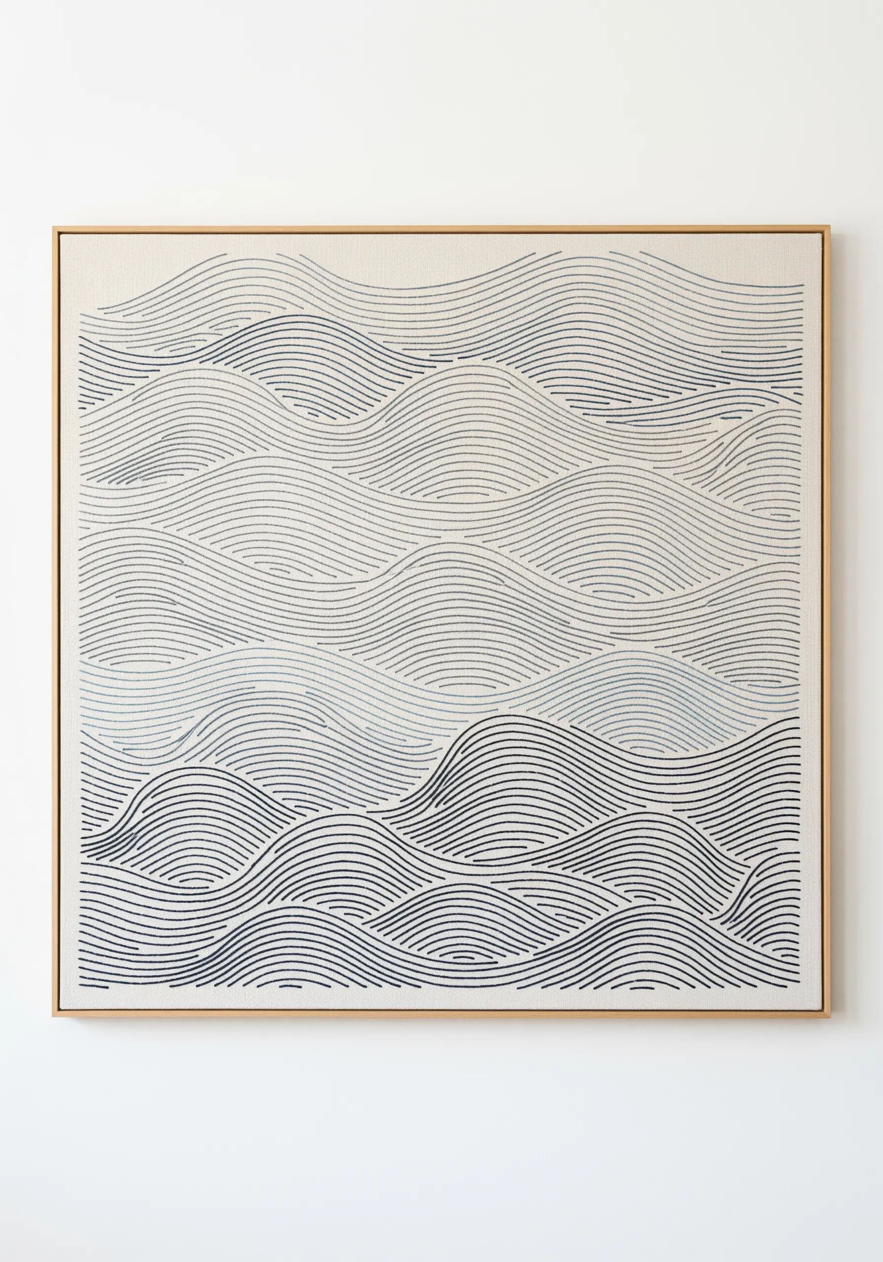 Framed embroidery of abstract ocean waves created with parallel blue and grey lines.
