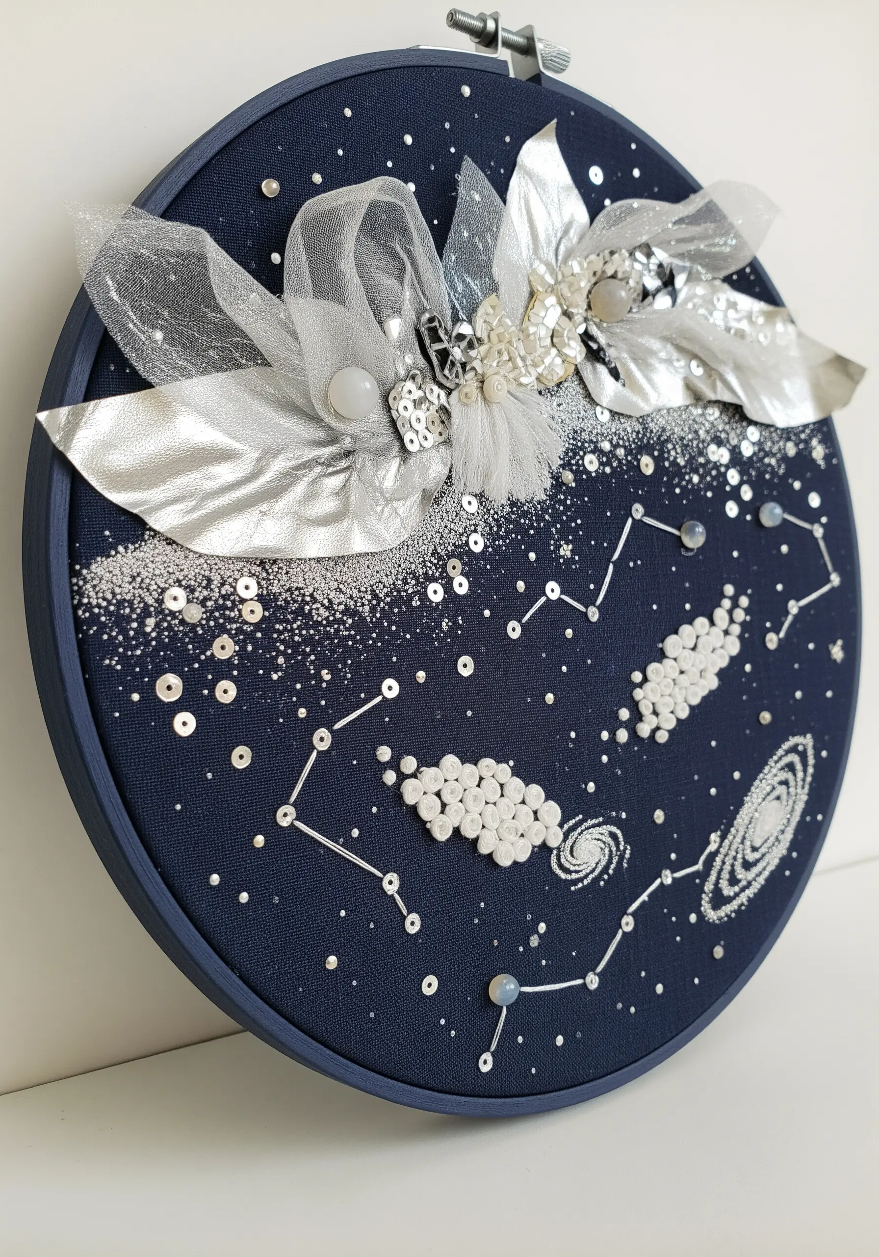 Celestial embroidery with beaded constellations, sequins, and a dimensional organza star.