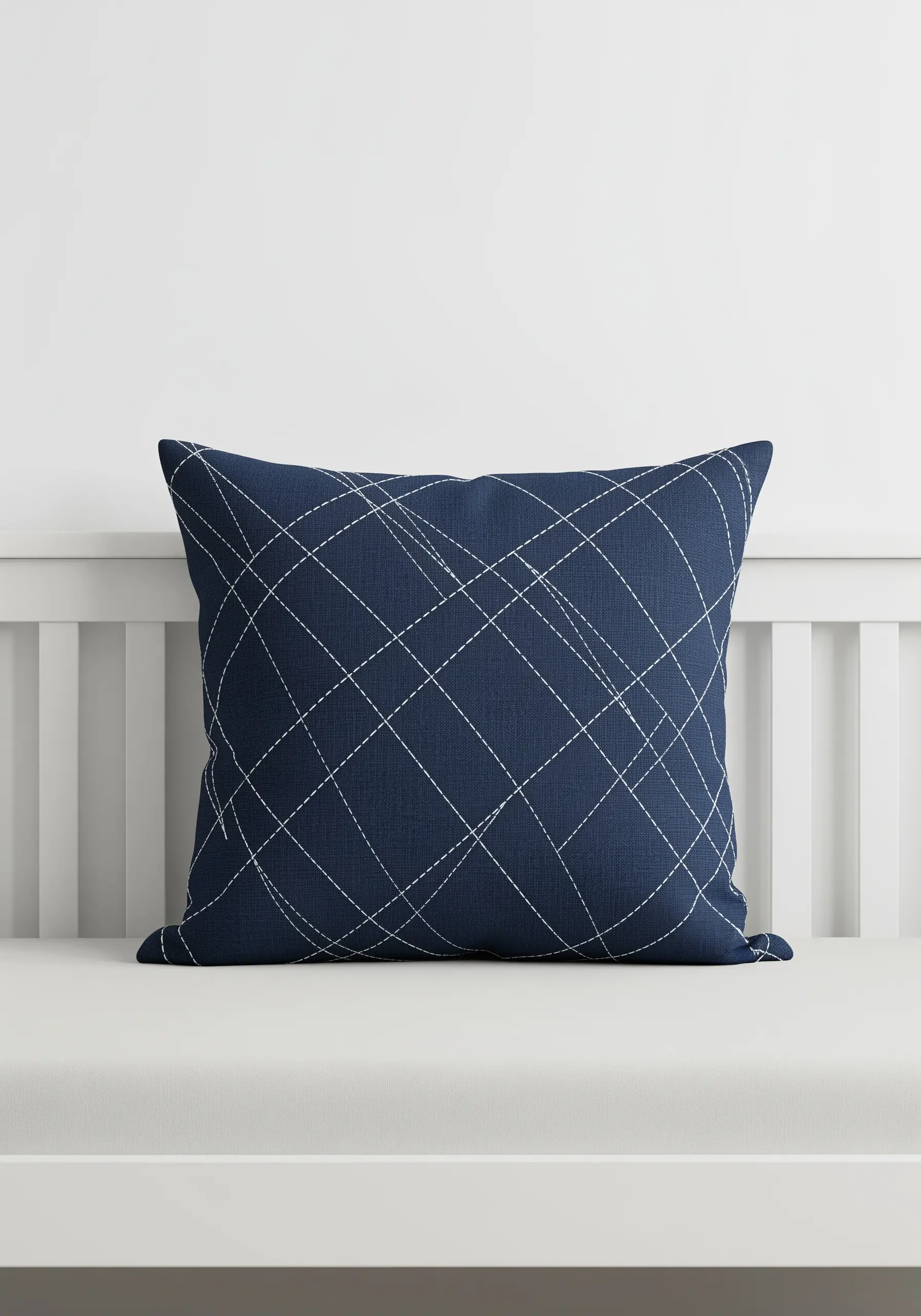 A navy blue pillow featuring a dynamic pattern of intersecting dashed lines in white thread.