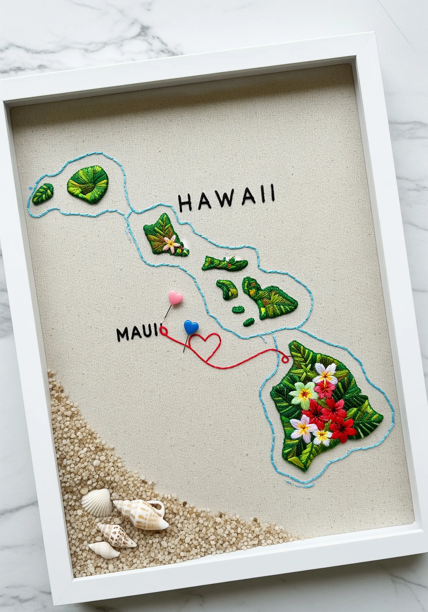 Embroidered map of Hawaii with 3D padded satin stitch flowers and real sand in the frame.