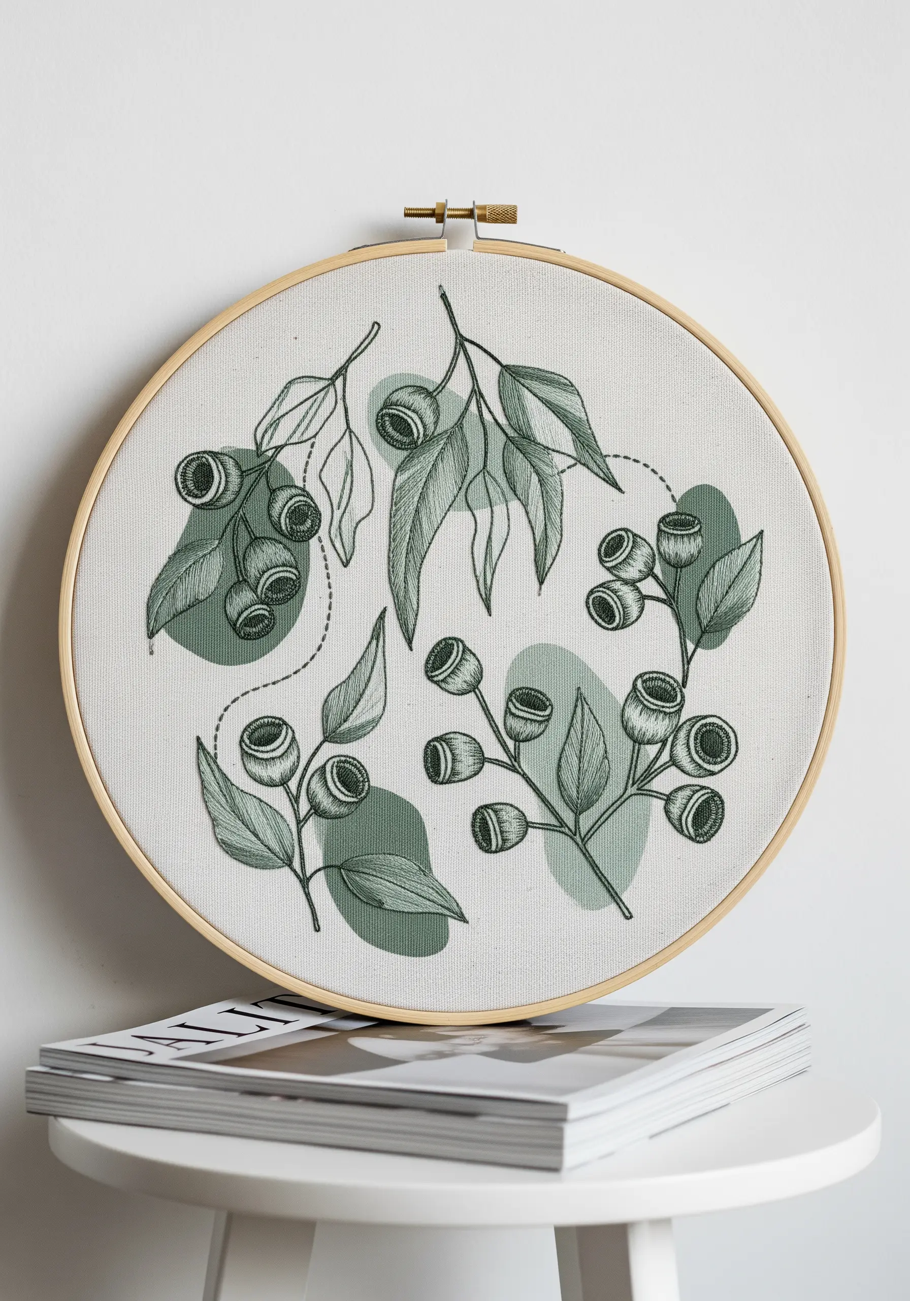 Eucalyptus embroidery with black line art stitched over green watercolor shapes.