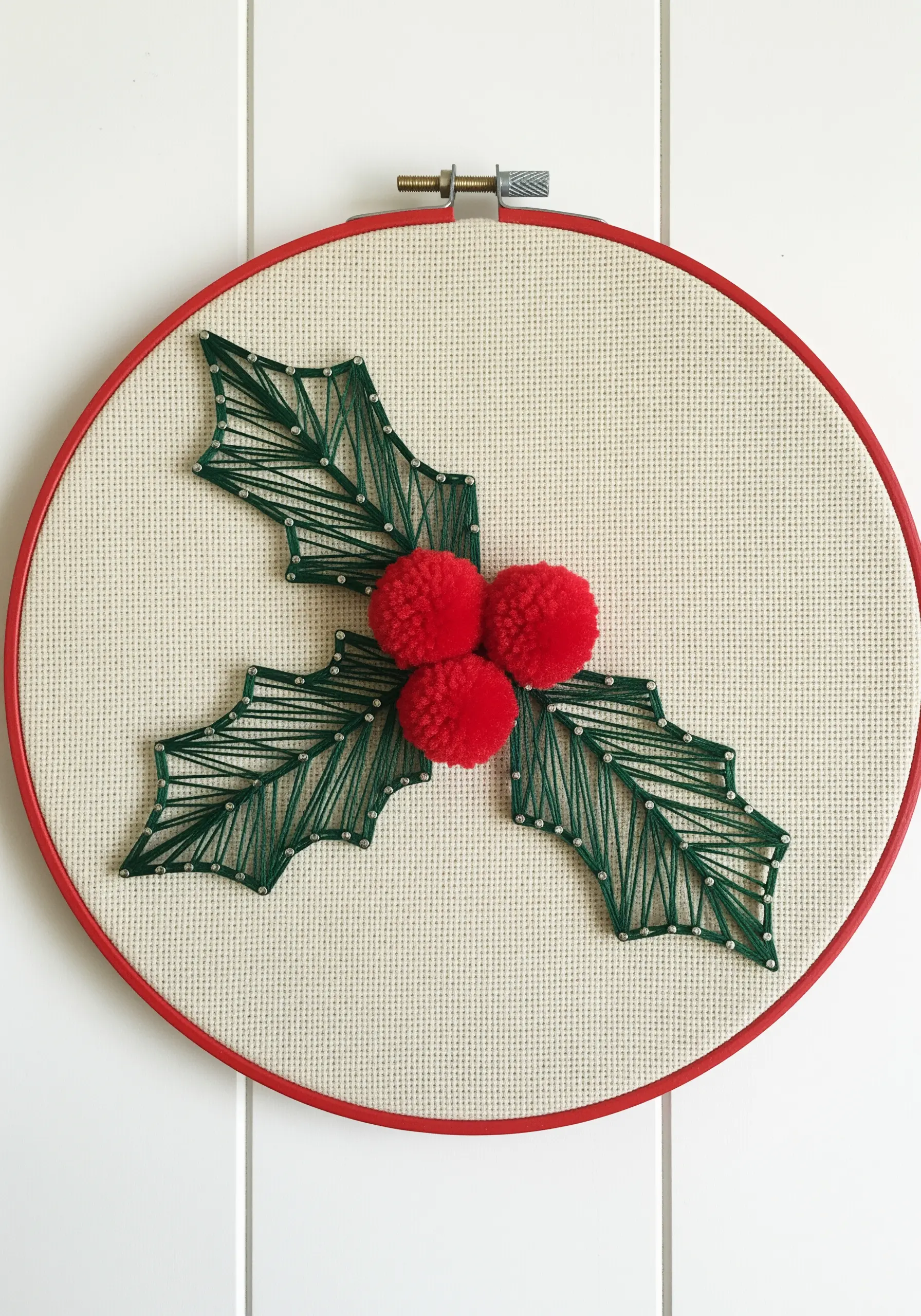 String art holly leaves embellished with three-dimensional red pom-pom berries.