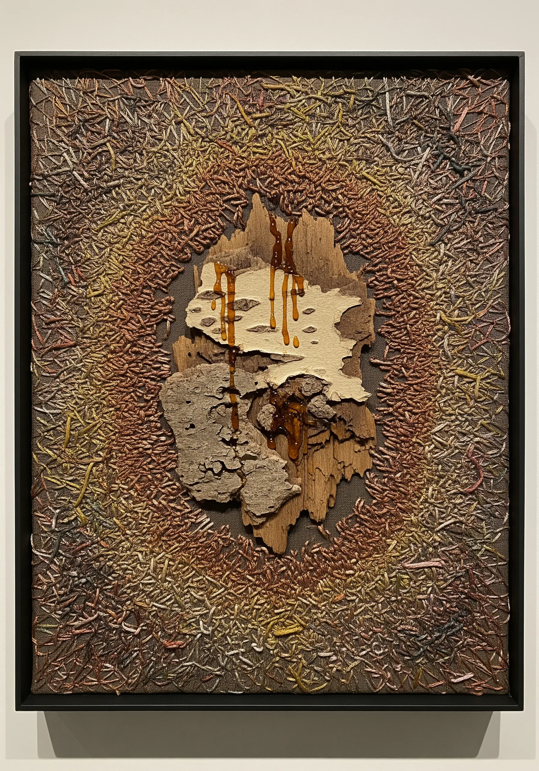 Mixed-media art combining real tree bark with abstract, textured embroidery.