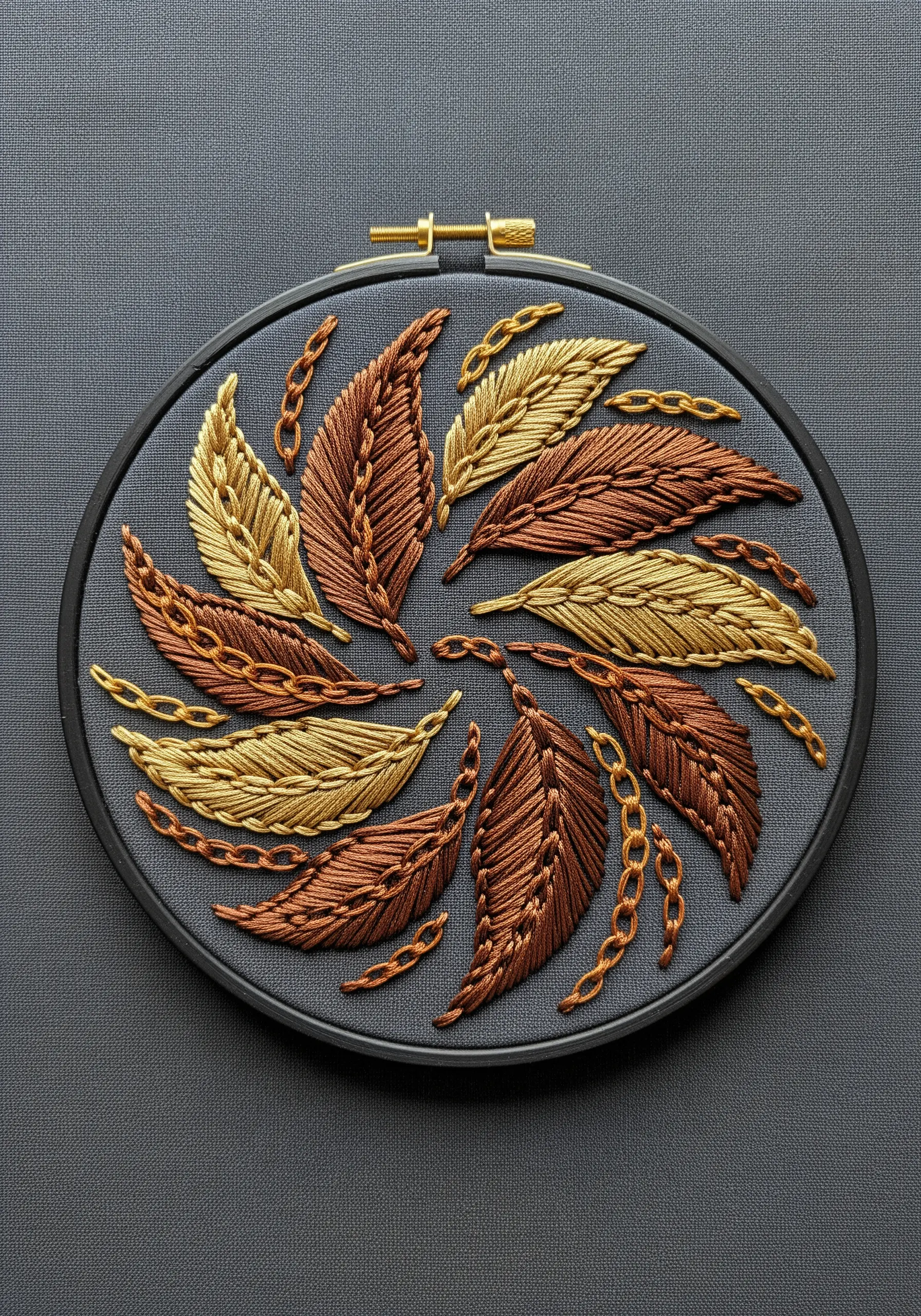 A circular composition of satin-stitched leaves in bronze and gold with metallic chain accents.