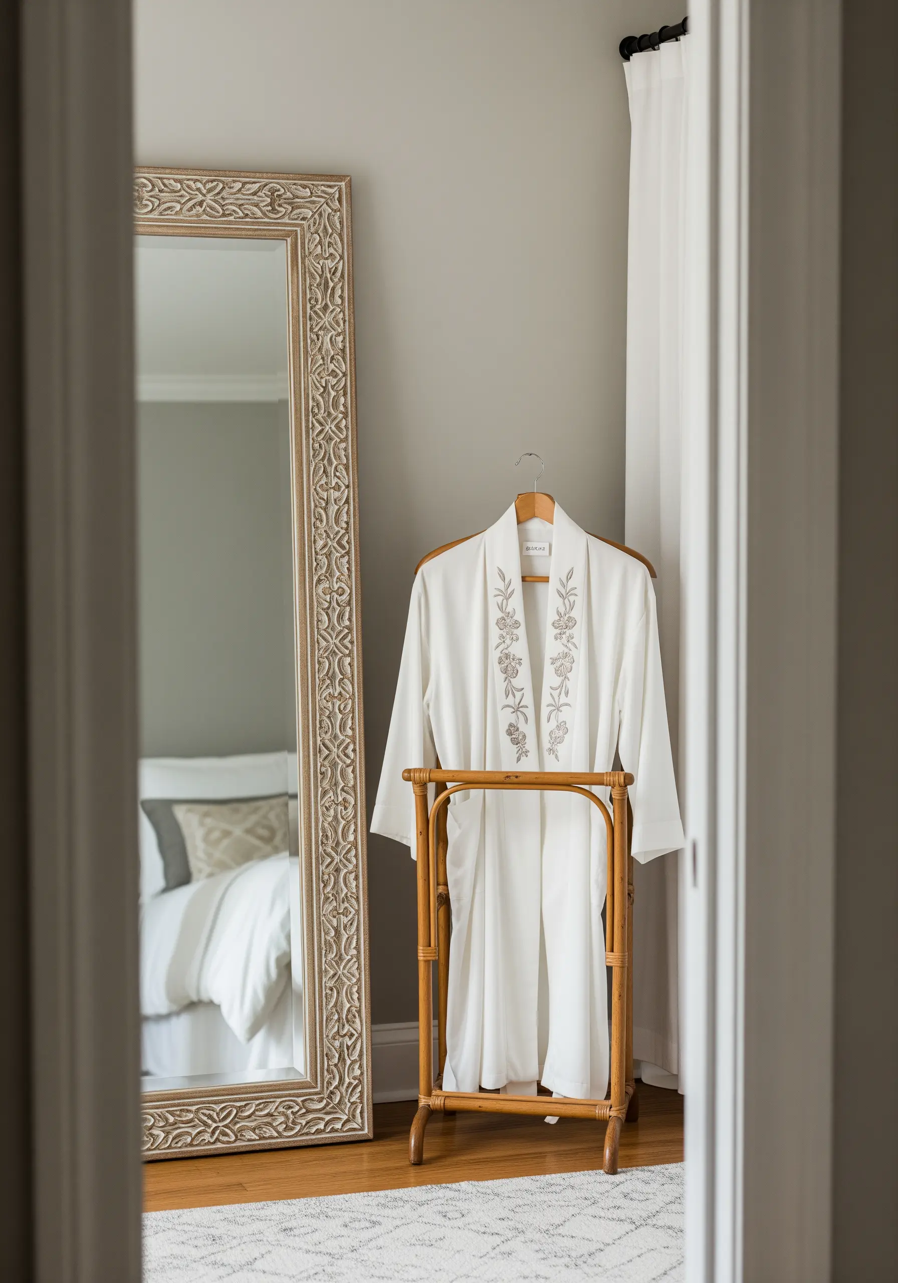 The lapel of a white robe featuring delicate floral spray embroidery in grey and greige thread.