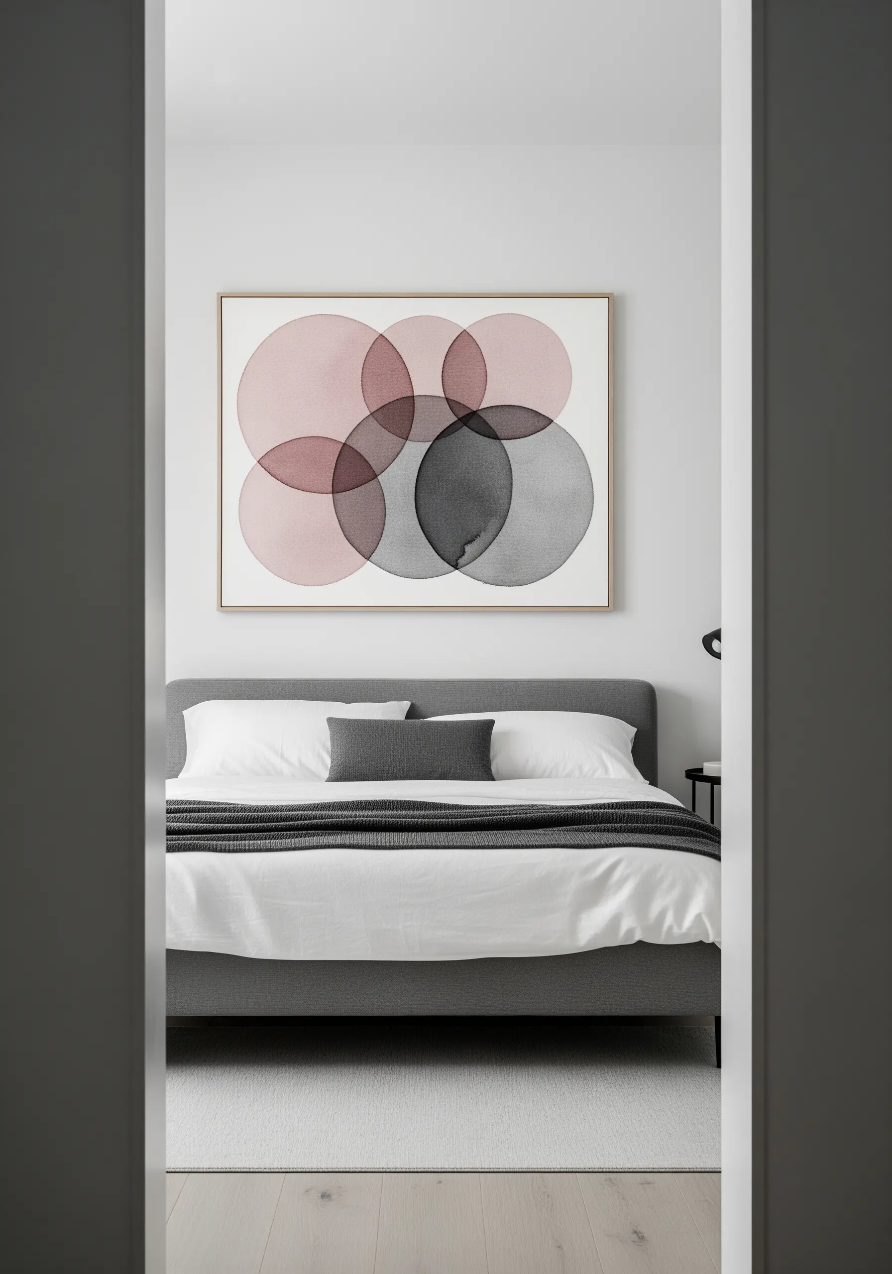 Framed embroidery of overlapping circles in pink and grey, creating a transparent effect.