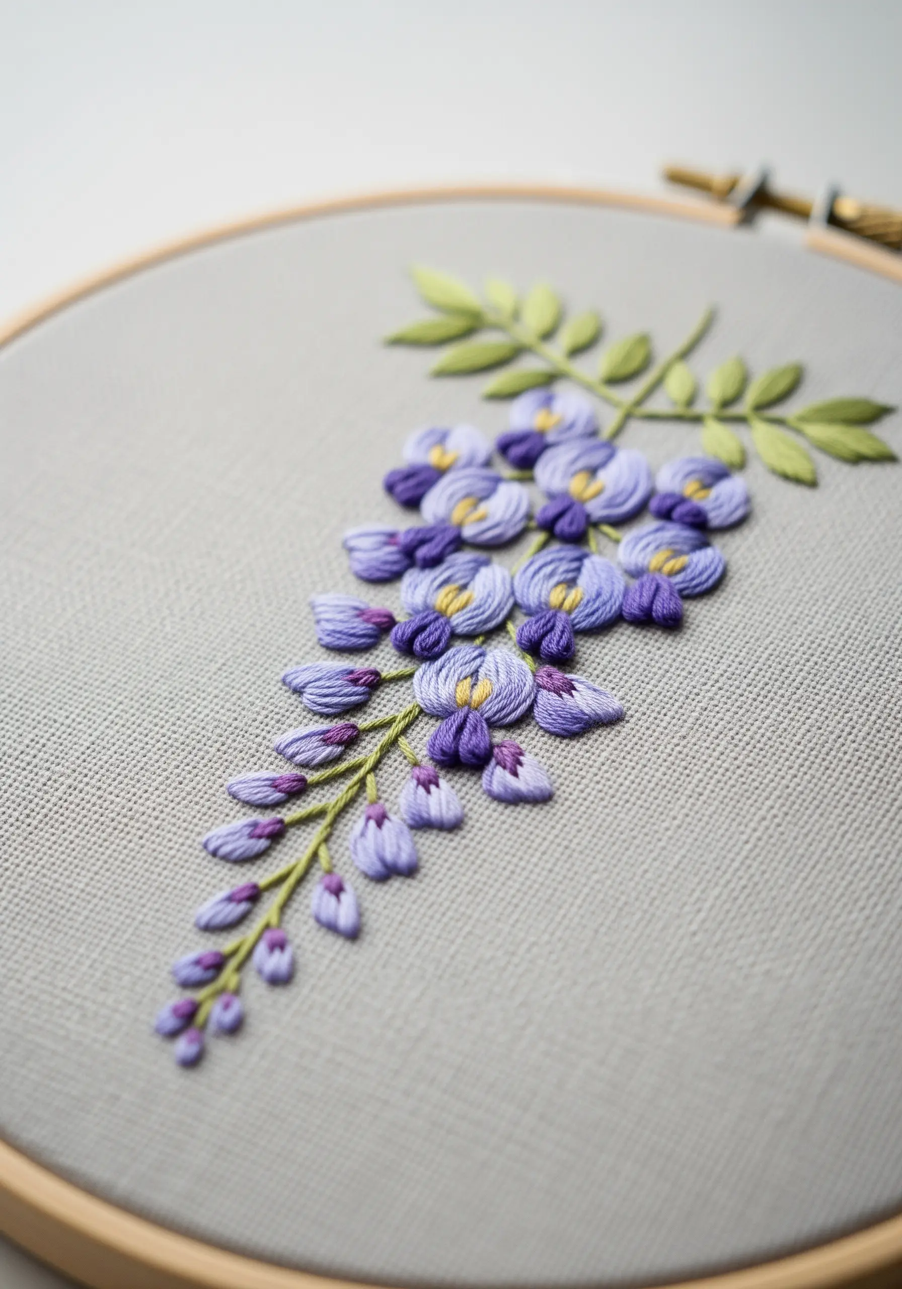Detailed embroidery of a cascading wisteria branch with purple, lavender, and yellow details.