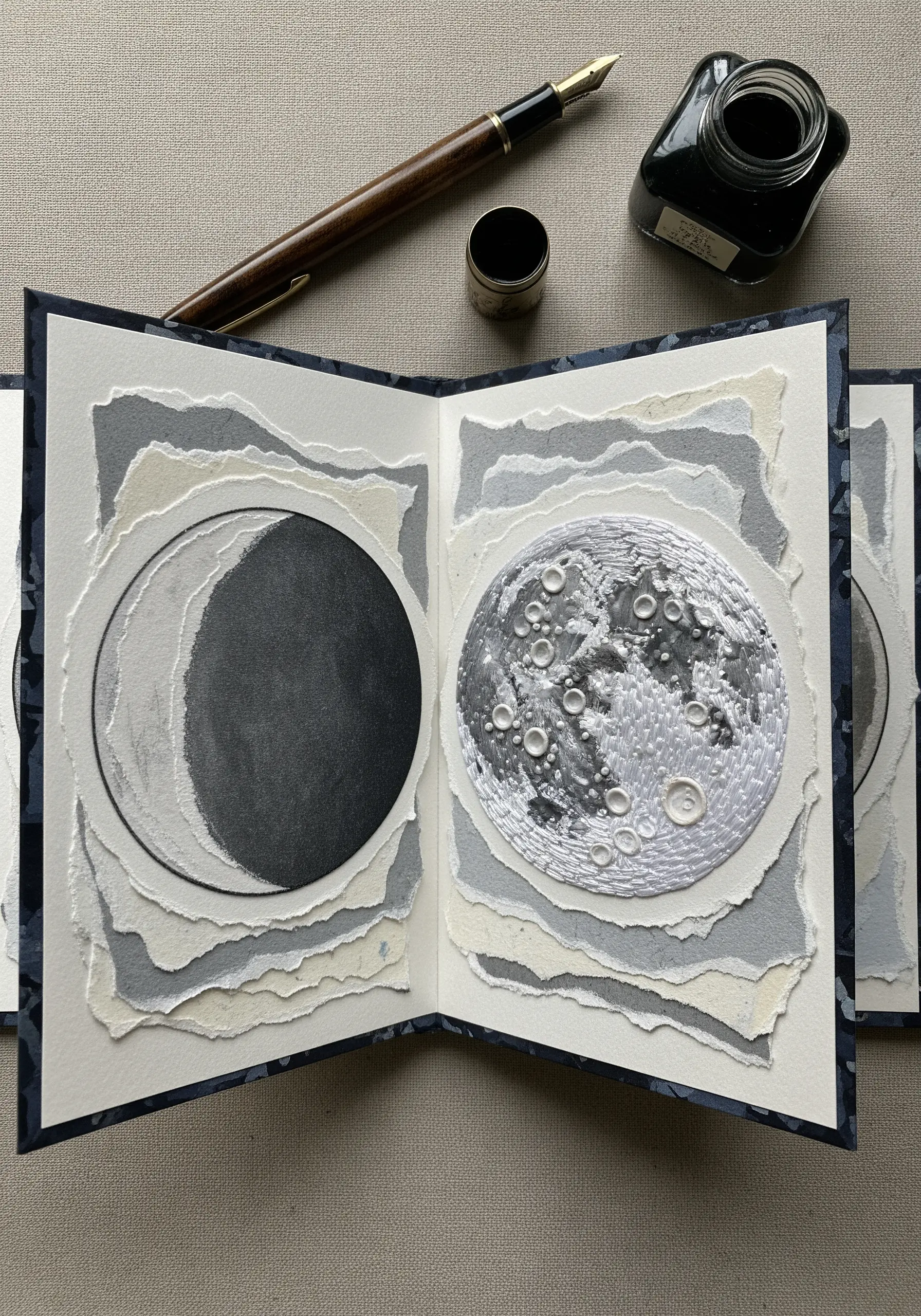 Art journal with layered torn paper and an embroidered full moon with French knots.