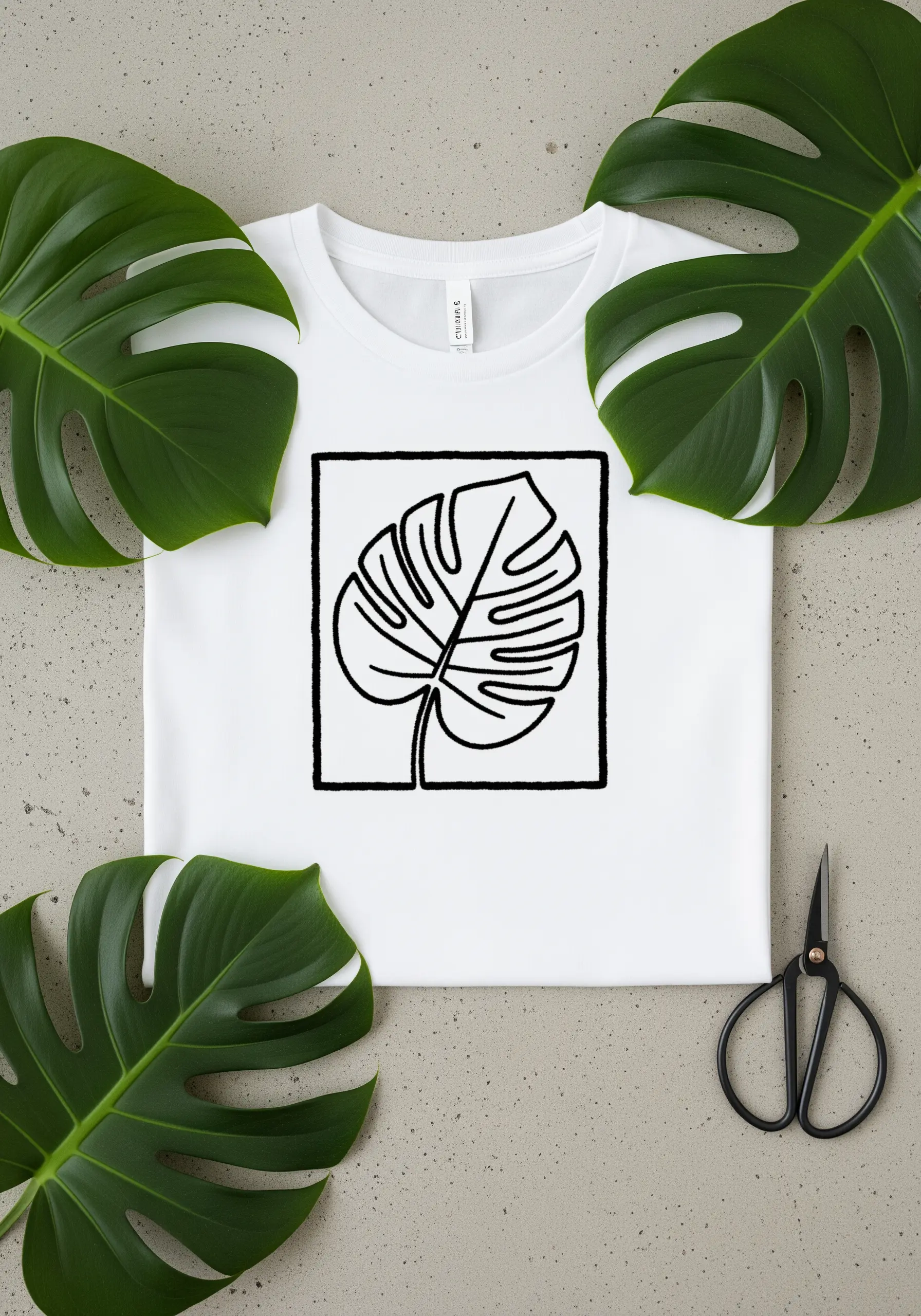 Bold black outline of a monstera leaf in a square on a white t-shirt.