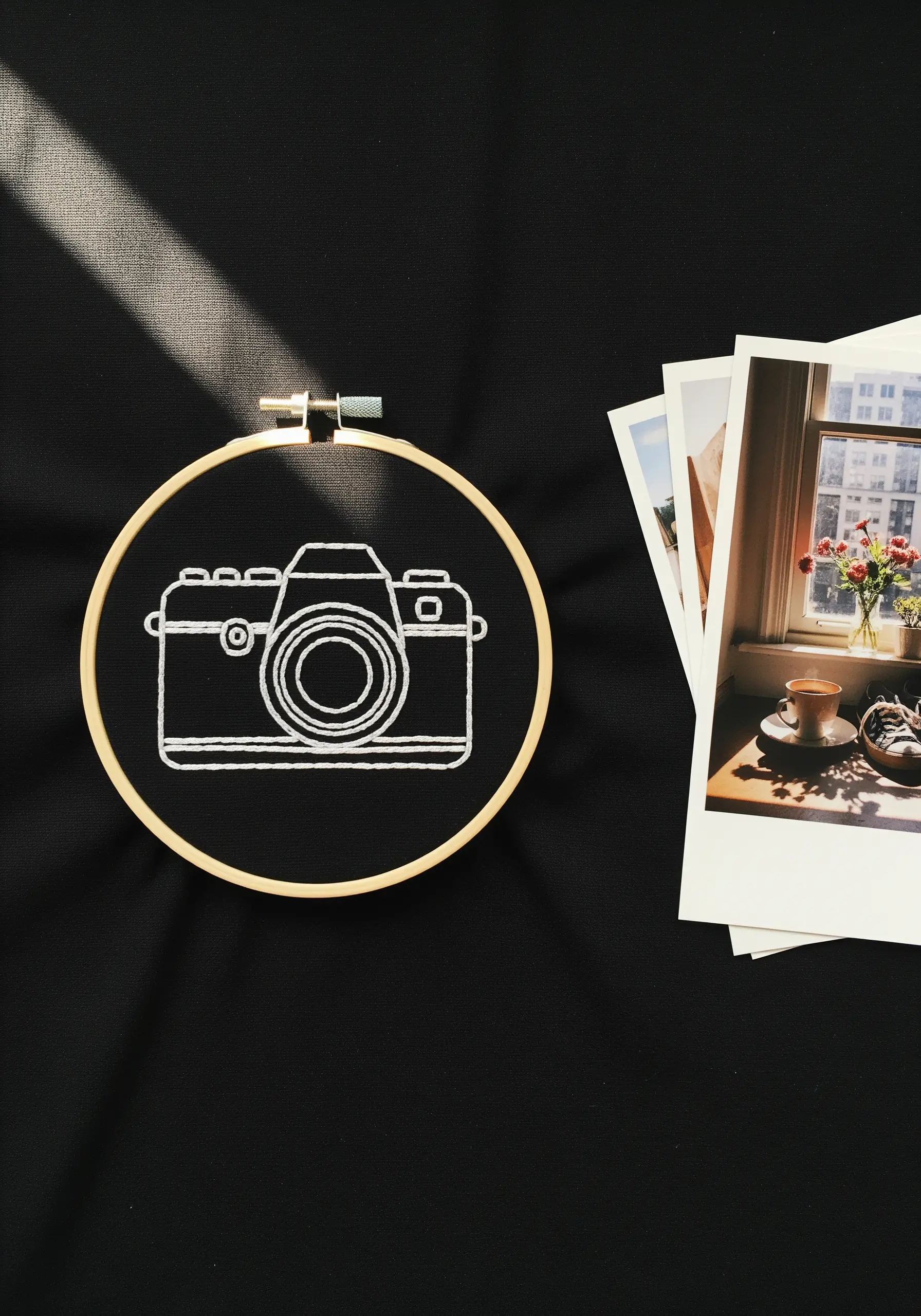 A vintage camera outlined in clean white backstitch on a stark black background.