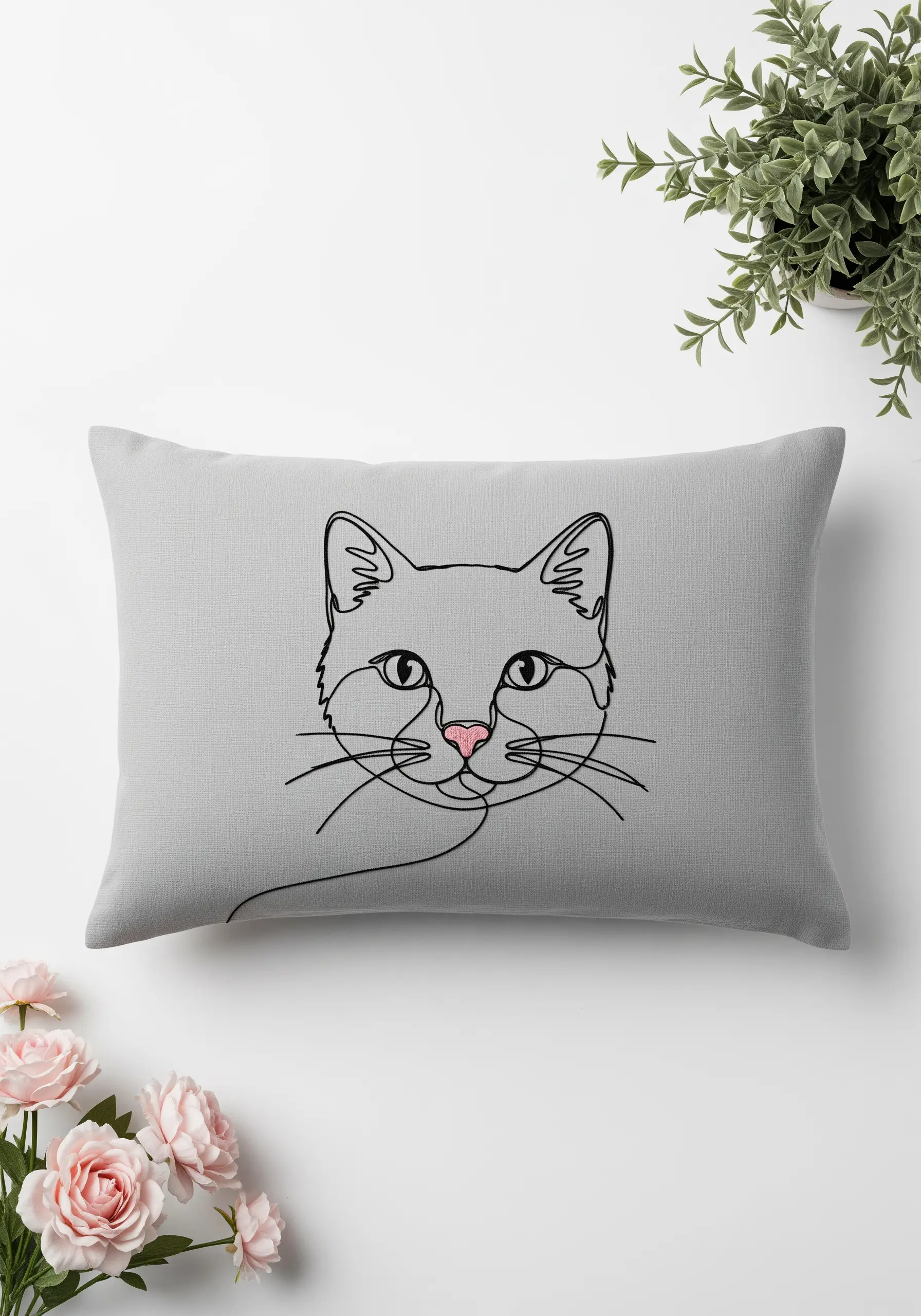 A continuous single-line art embroidery of a cat's face on a grey pillow.