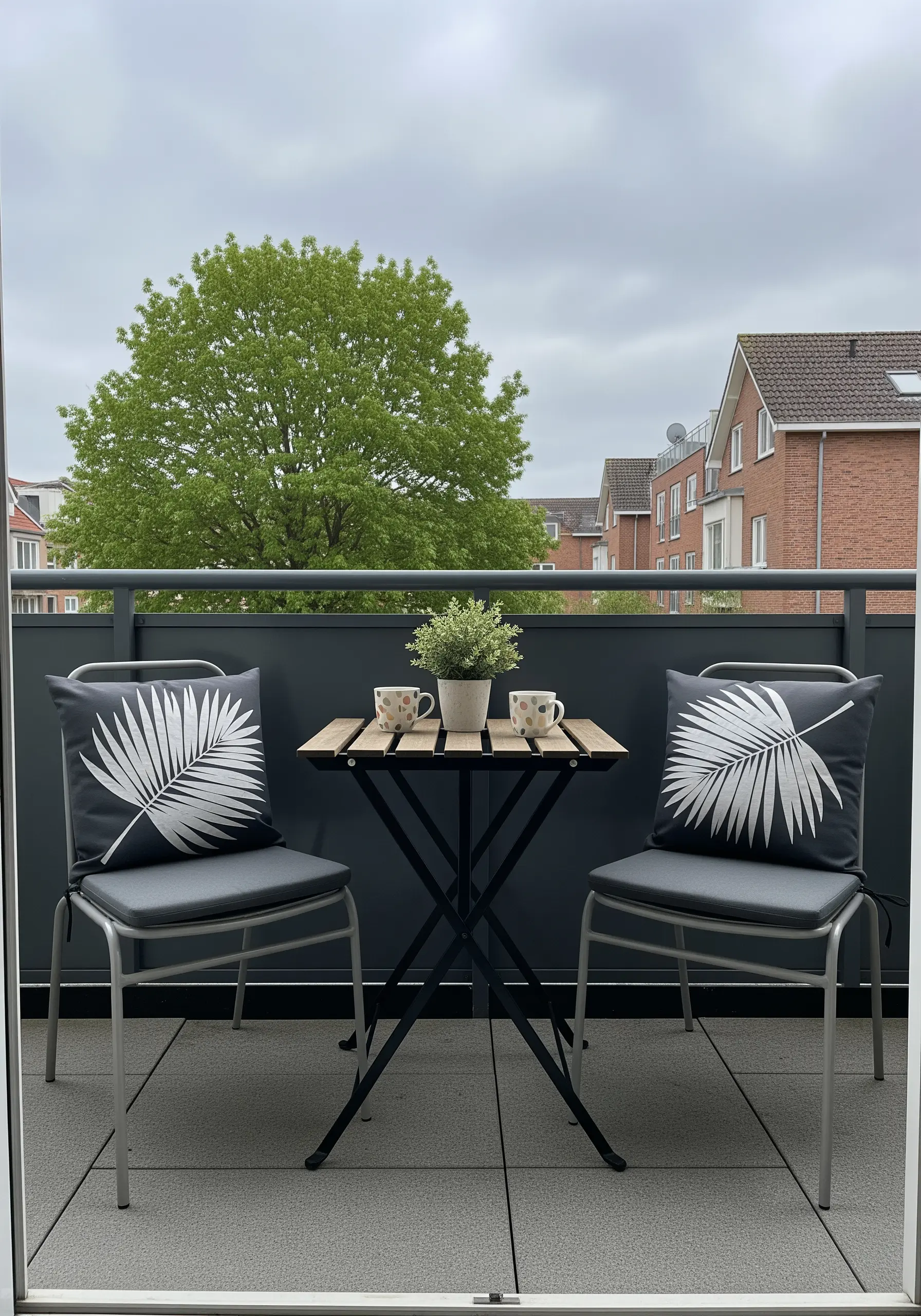 Dark gray outdoor cushions with a large, bold white embroidered palm leaf