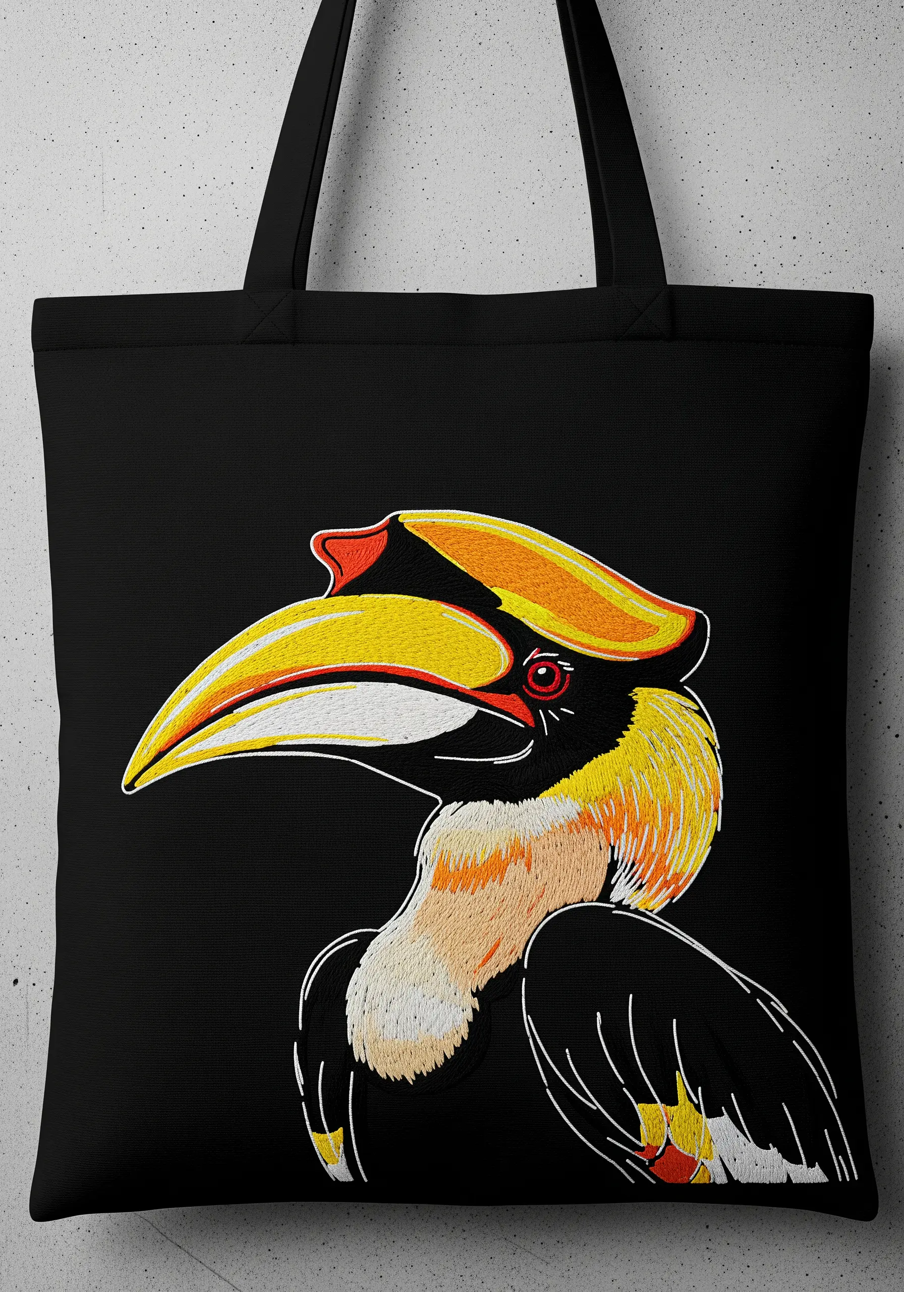 A yellow-billed hornbill embroidered with high-contrast colors on a black tote bag.