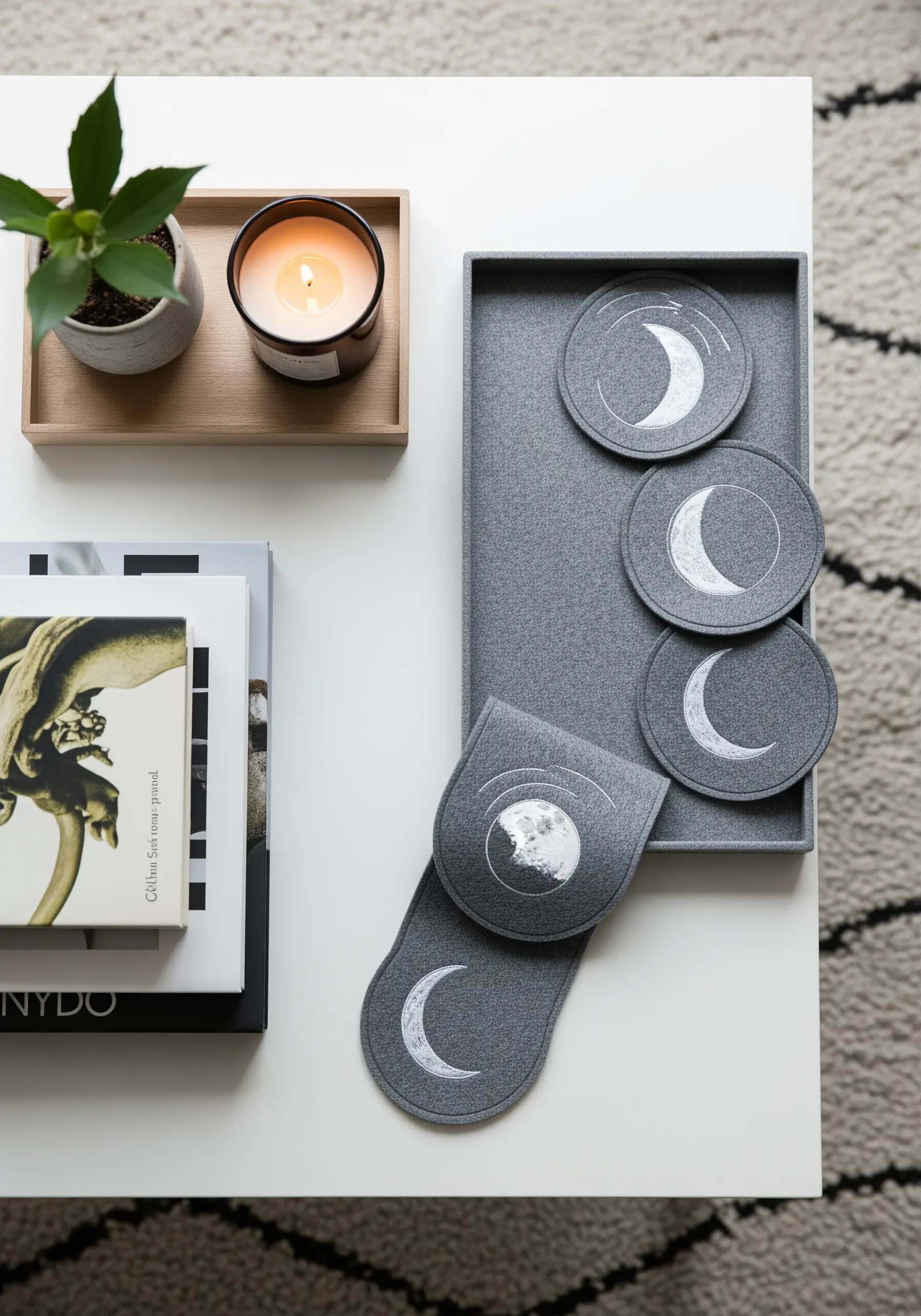 A set of dark gray felt coasters embroidered with different phases of the moon