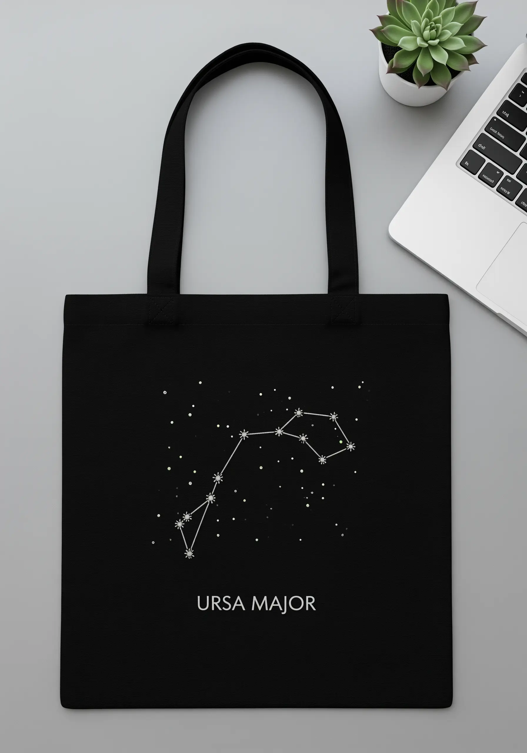 Ursa Major constellation embroidered in white thread on a black canvas tote bag.