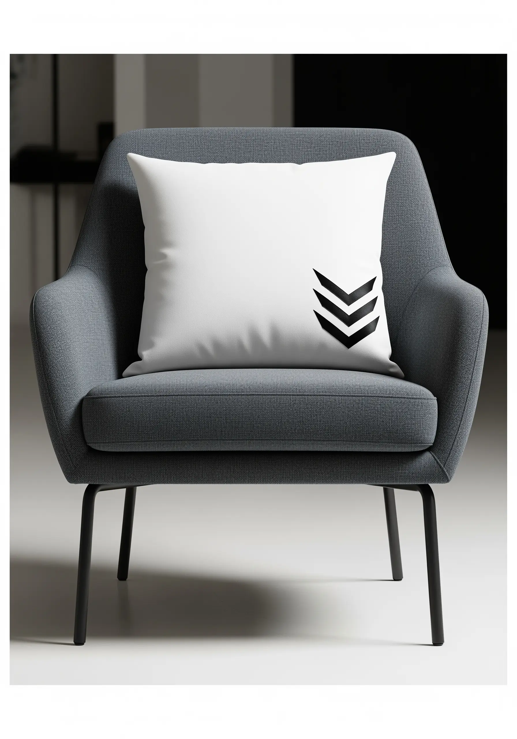 A stark white pillow with a bold, black satin-stitched chevron motif in the corner.