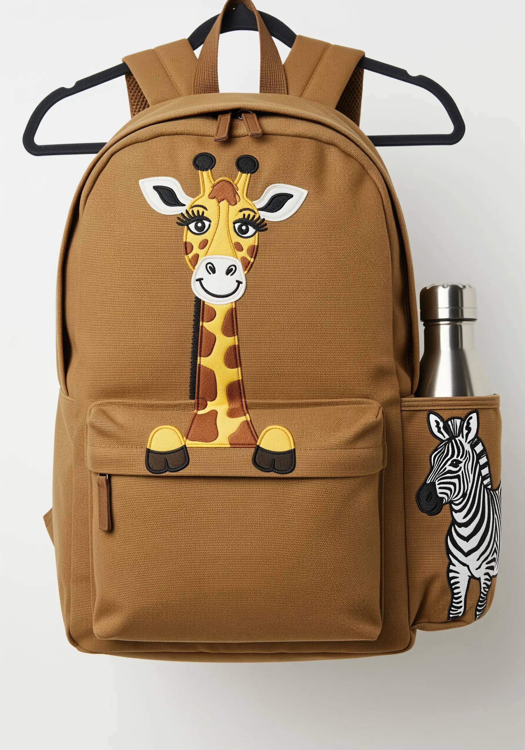 A large, friendly cartoon giraffe embroidered on the front pocket of a brown canvas backpack