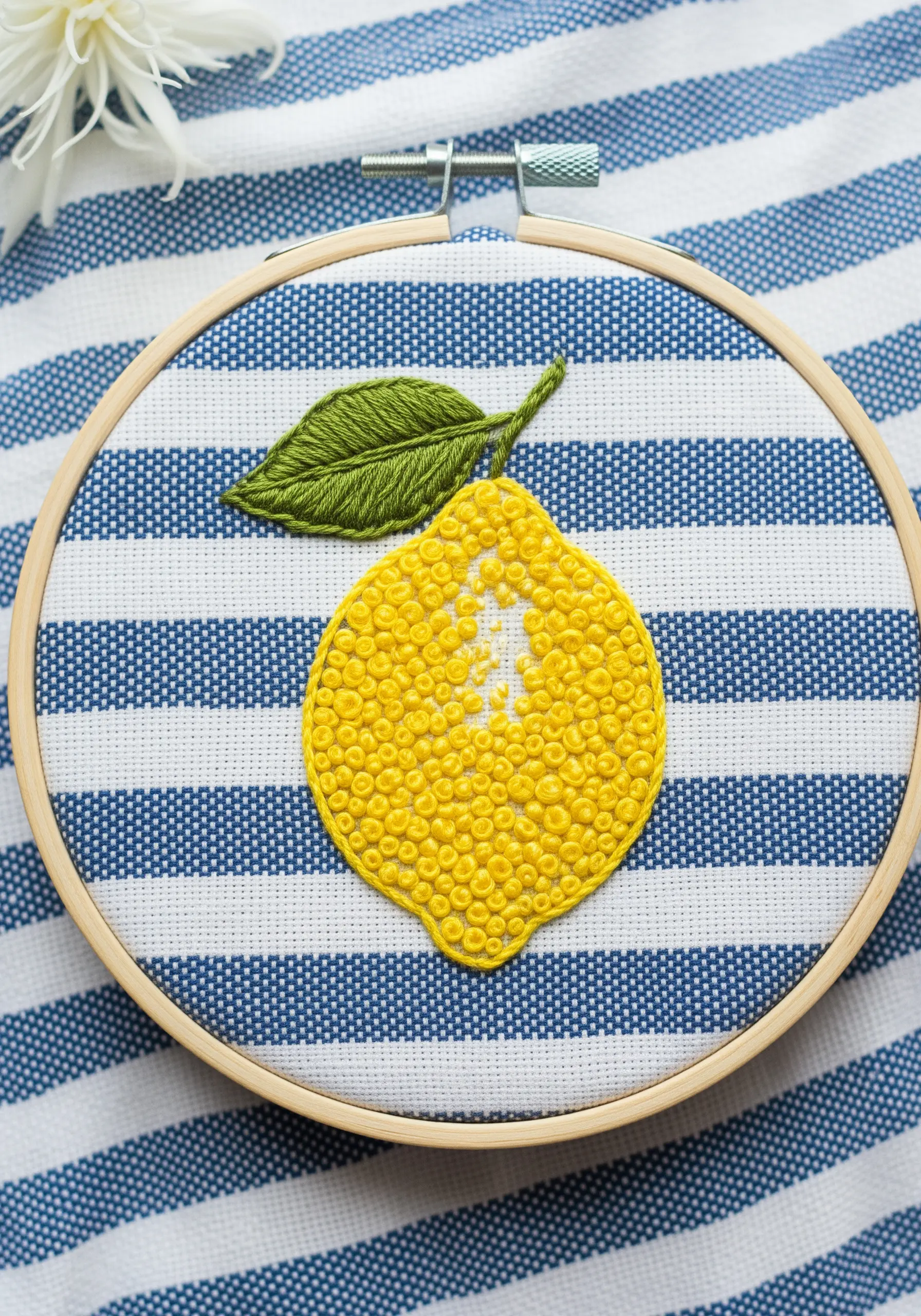 An embroidered lemon filled with dense yellow French knots to create a rind texture.