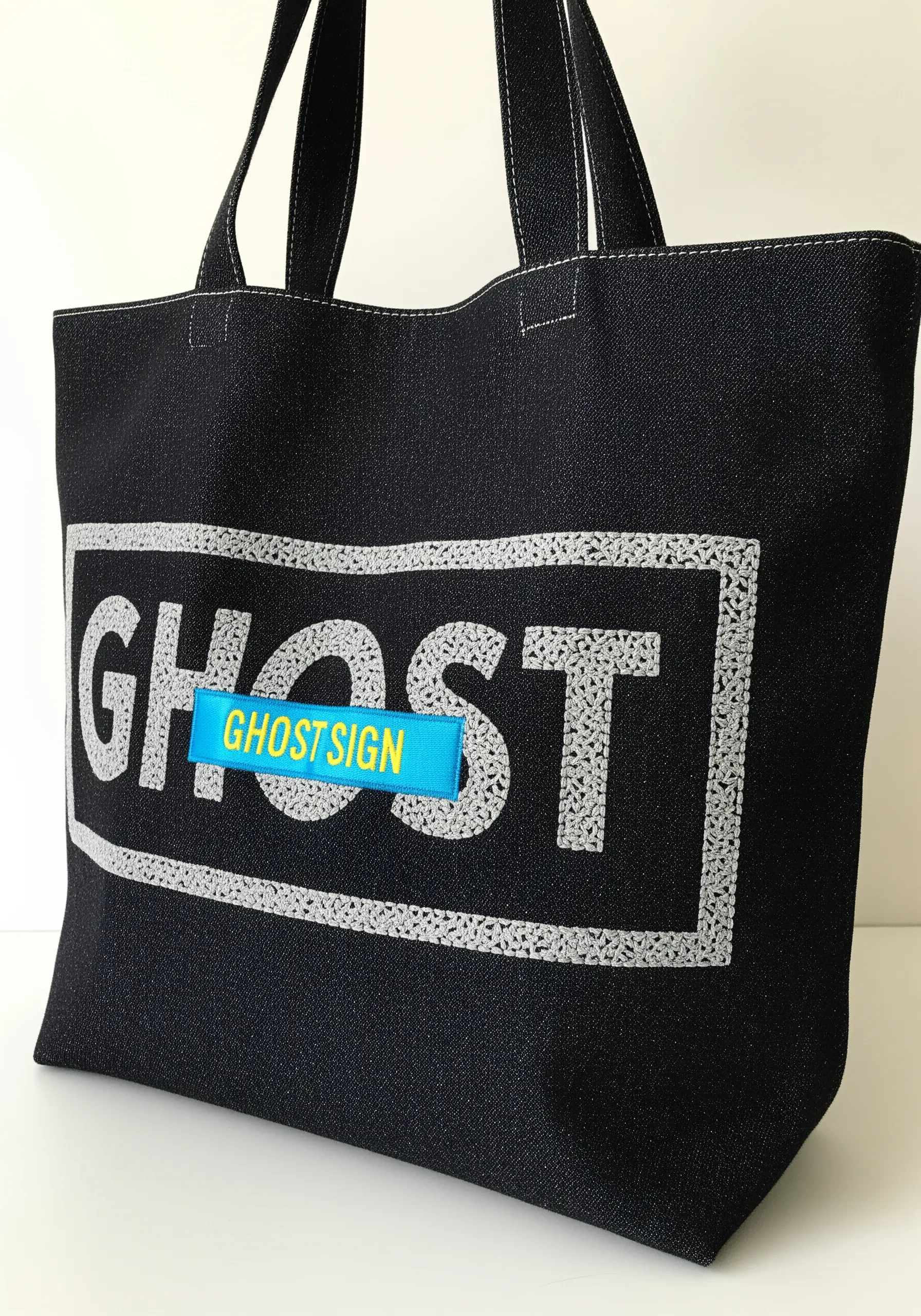 Text embroidered with a textured French knot fill to look like a faded sign.