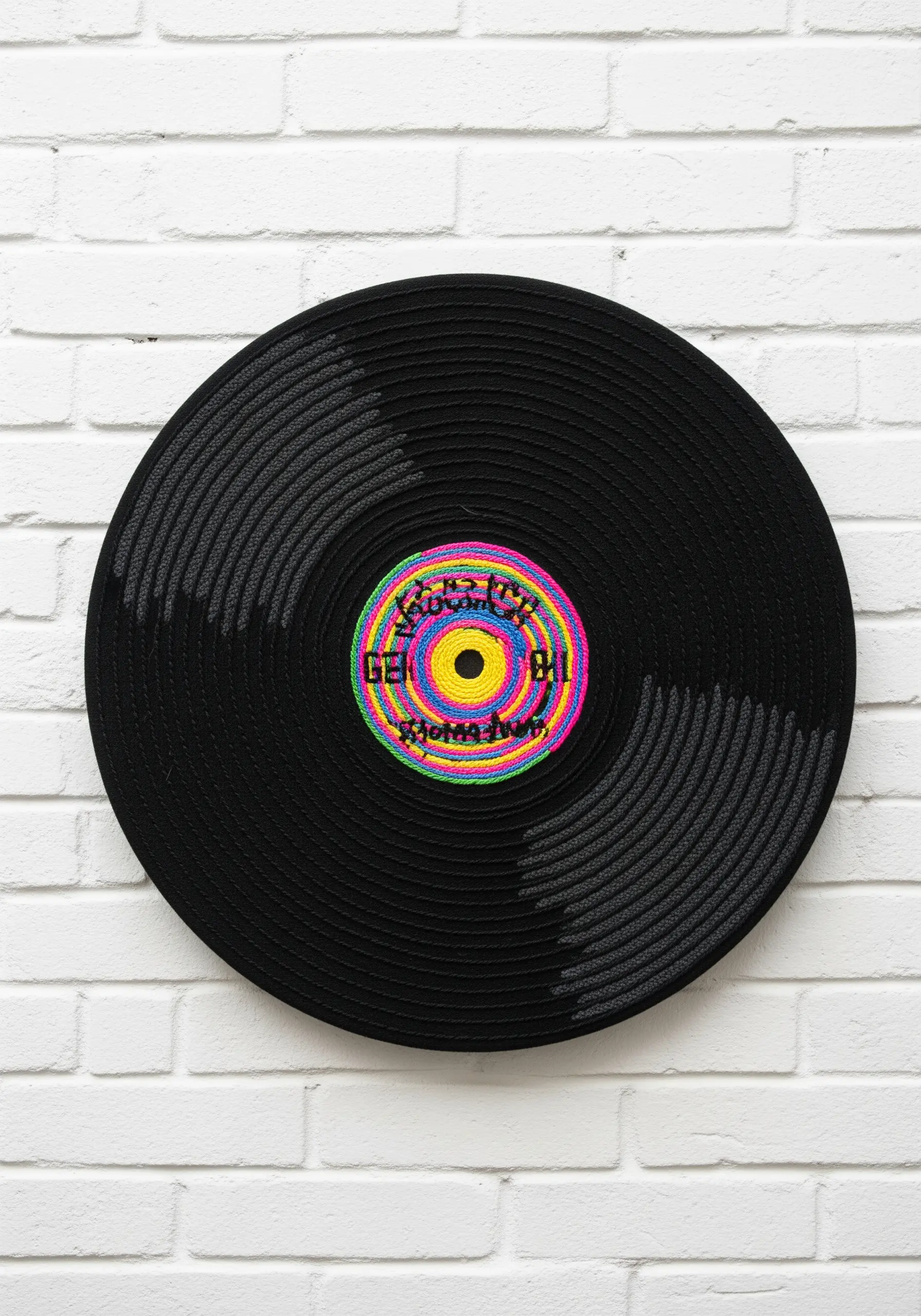A large embroidered vinyl record with a colorful center label.