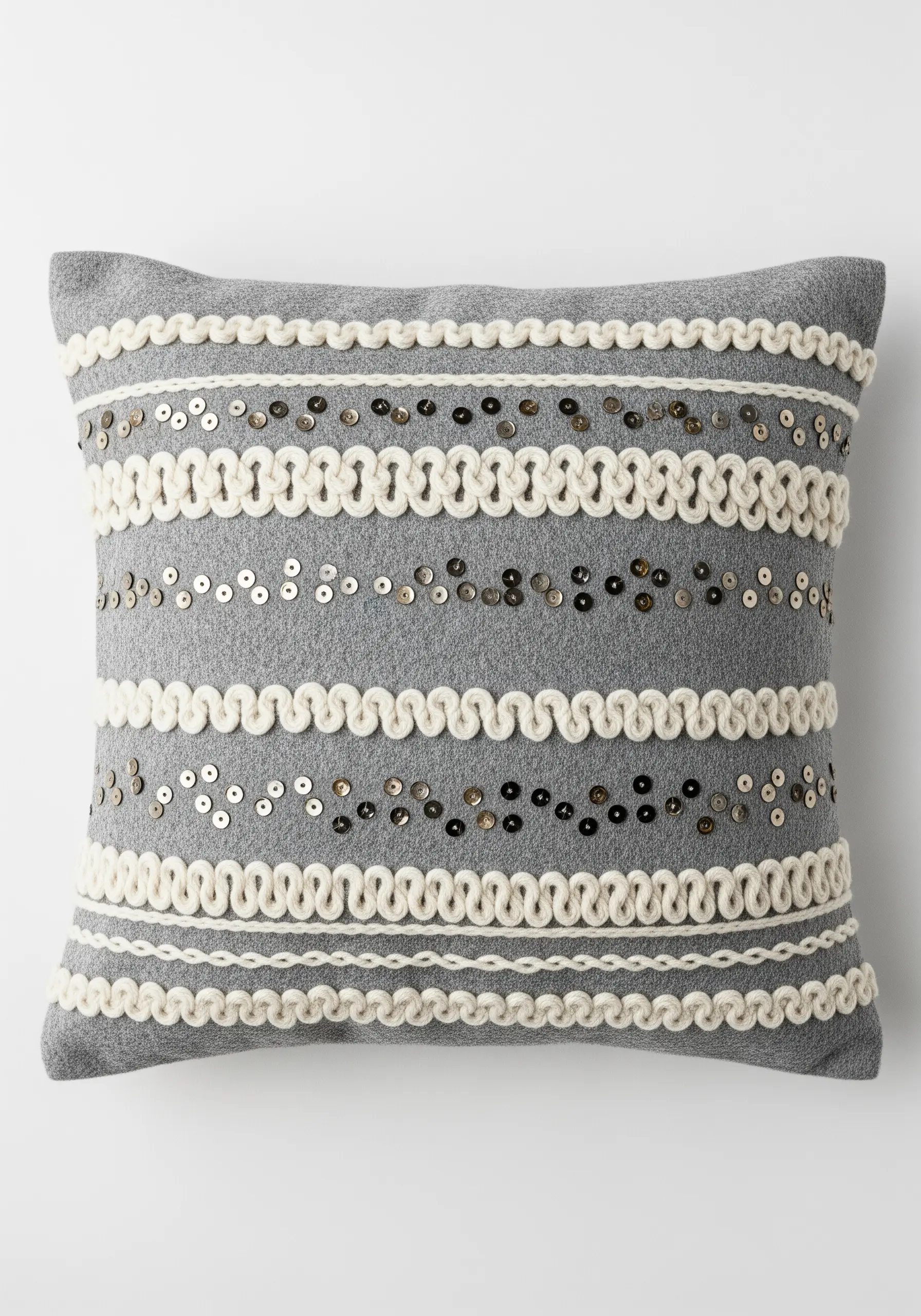 A grey wool cushion with lines of couched cream wool and scattered silver sequins