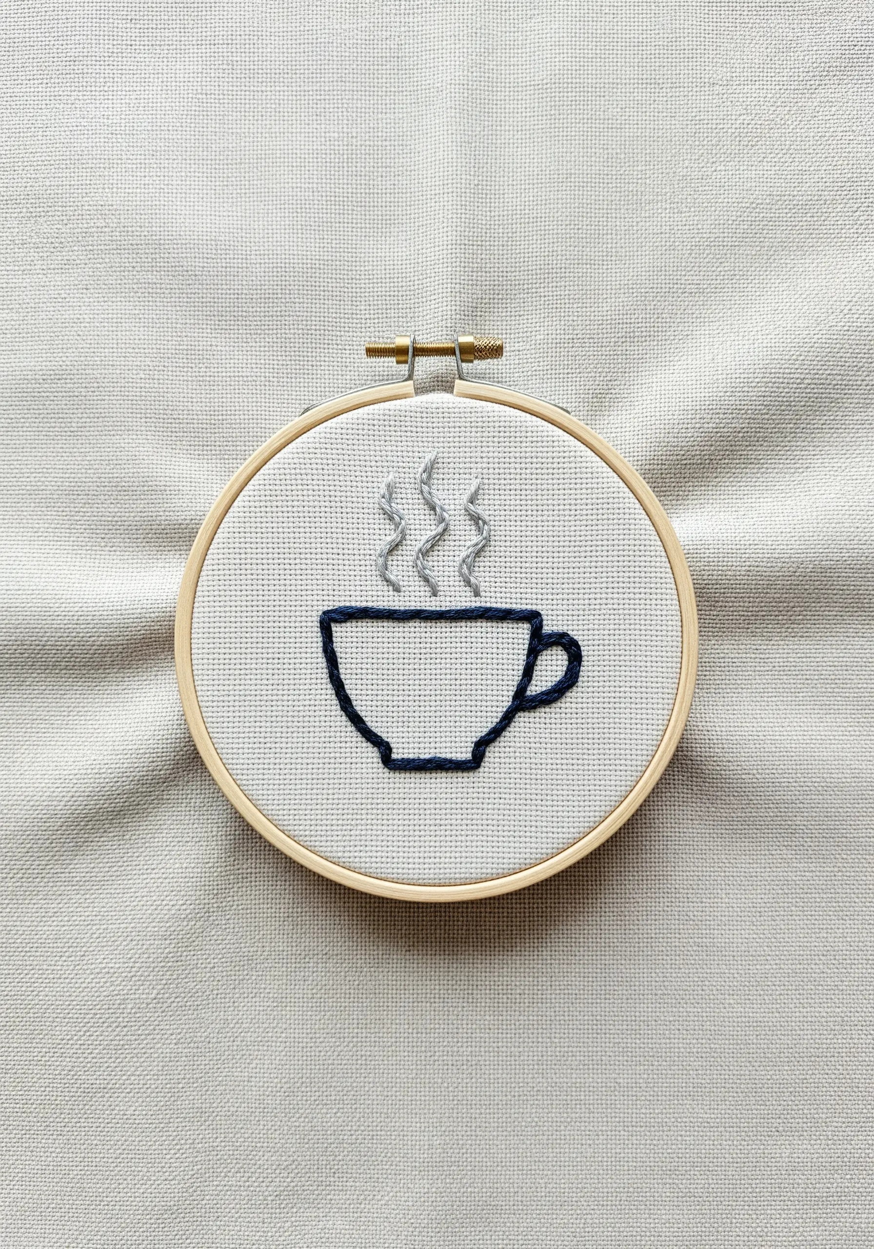 Outline embroidery of a coffee cup with wavy lines for steam.