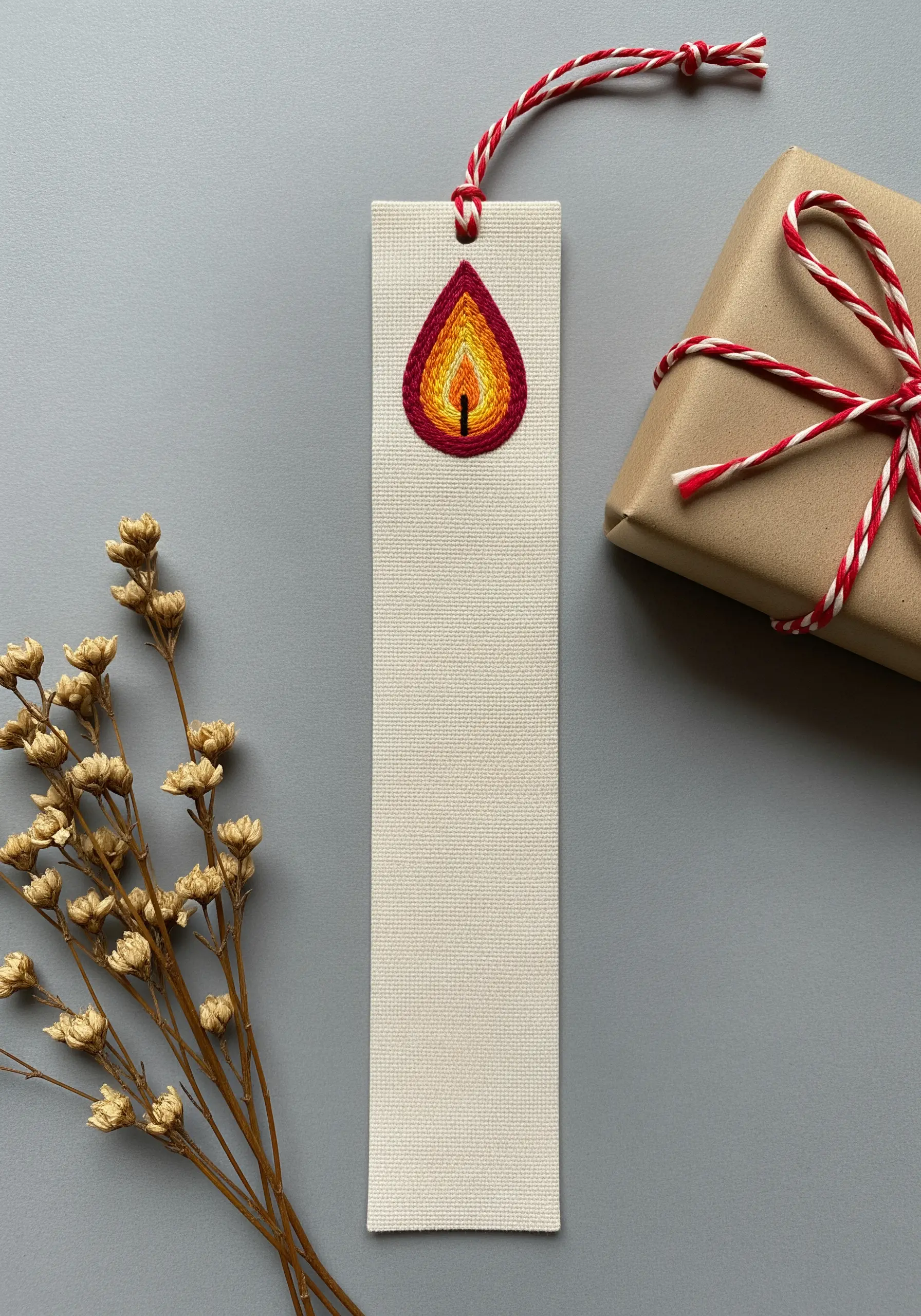 Thread-painted candle flame on a bookmark, blending from red to yellow.