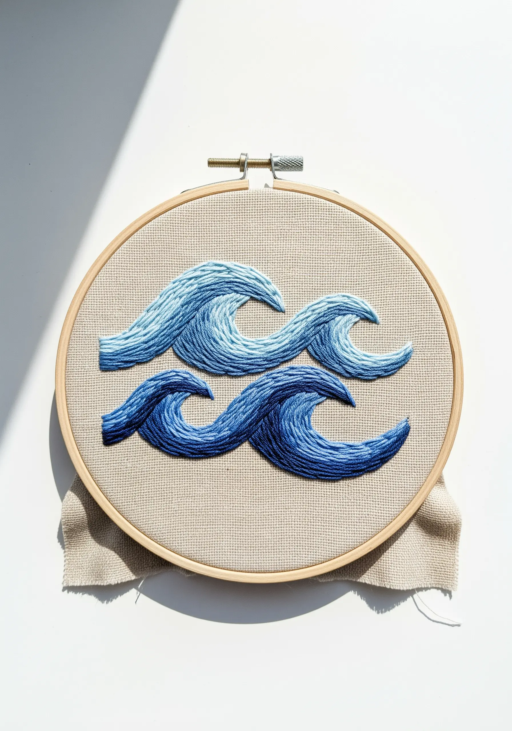 Stylized ocean waves embroidered with long-and-short stitch in shades of blue.