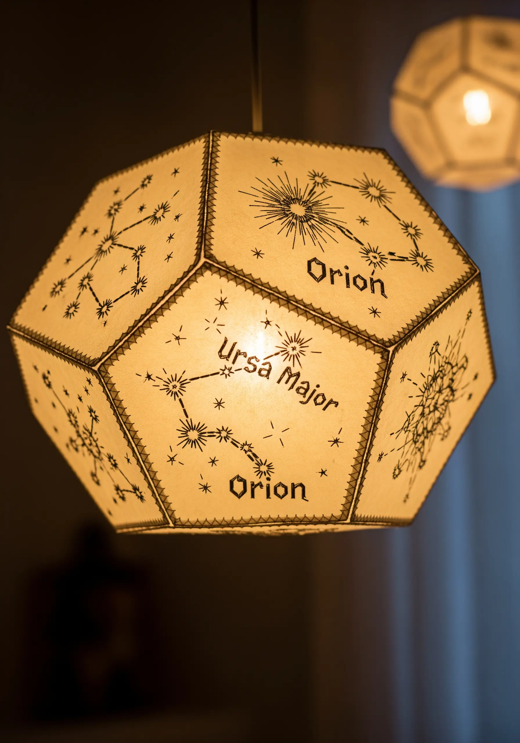 A geometric paper lampshade illuminated from within, showing pierced constellation patterns.