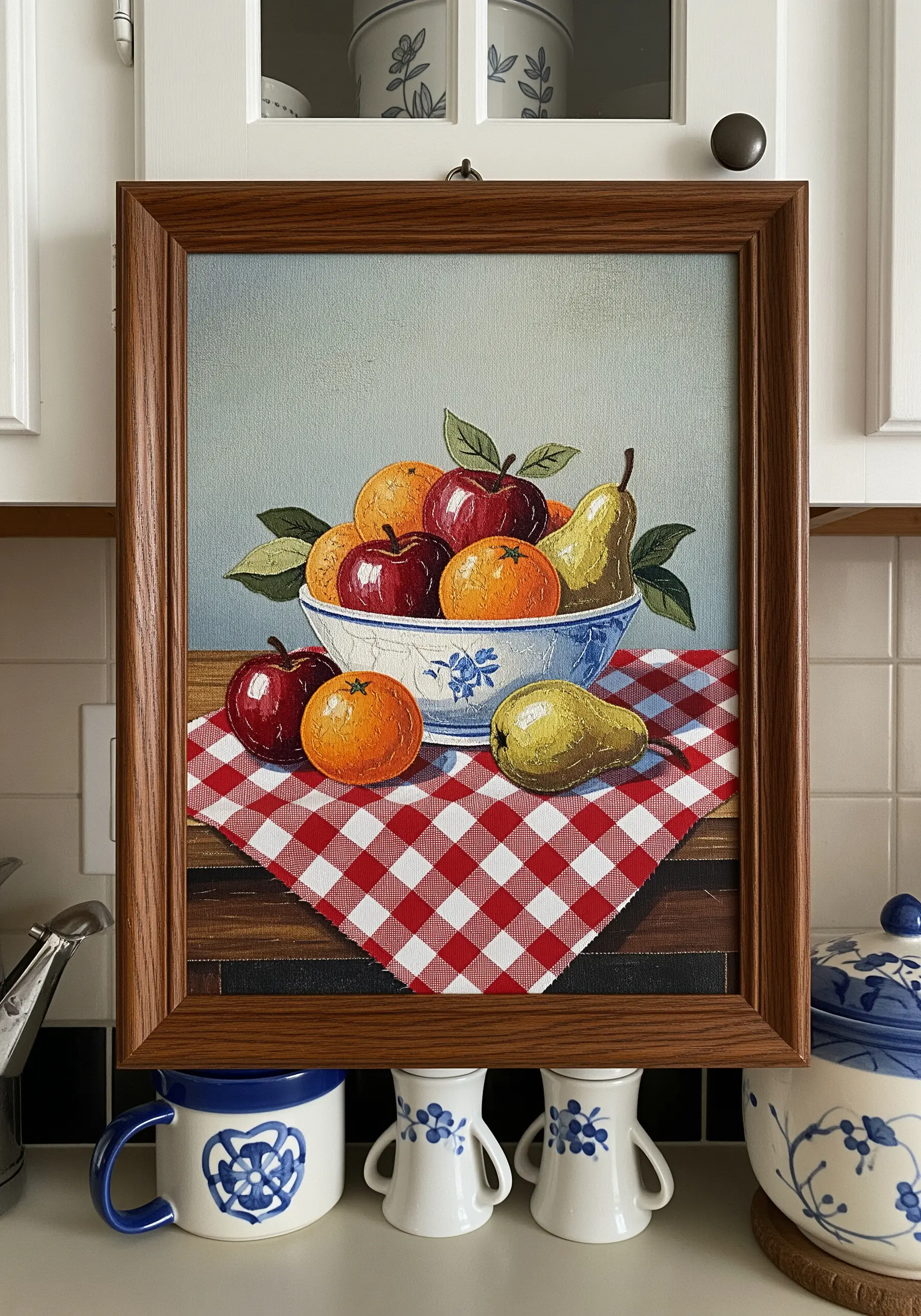 Framed still life of a fruit bowl where the tablecloth is gingham fabric appliqué.